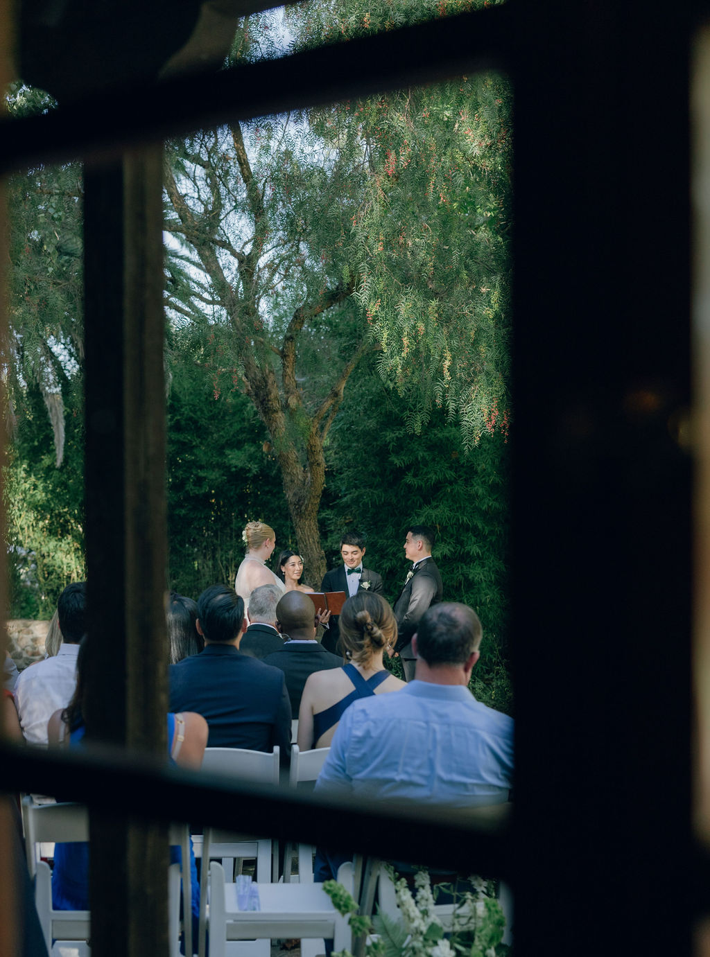 Bride and groom wedding ceremony photo taken through indoor glass door