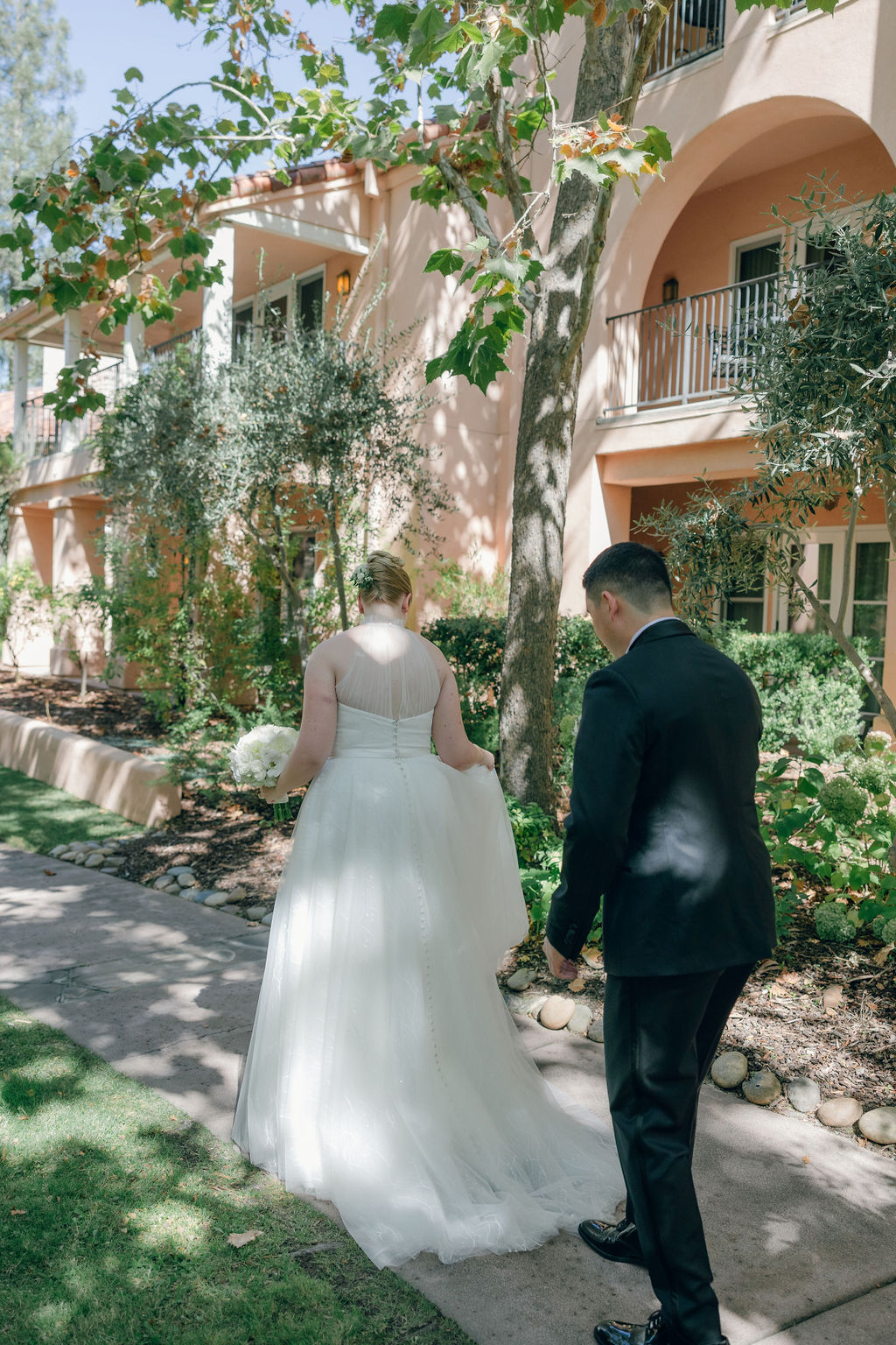 Bride and groom walking through courtyard at Cline Family Cellars wedding