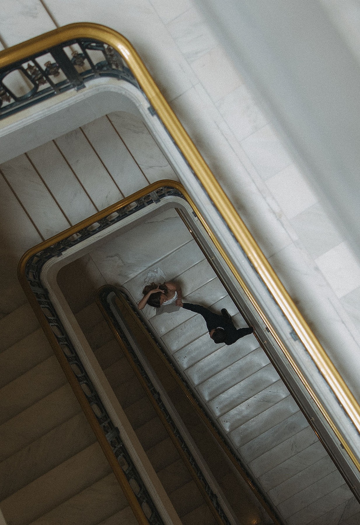 Arial photo of bride and groom walking down staircase at wedding at San Francisco city hall