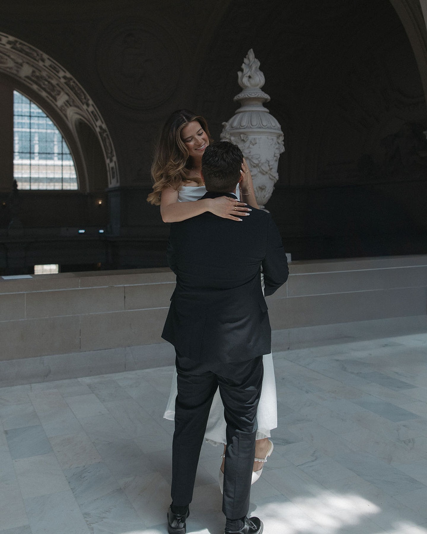 Groom holding and spinning his bride to celebrate their city hall elopement