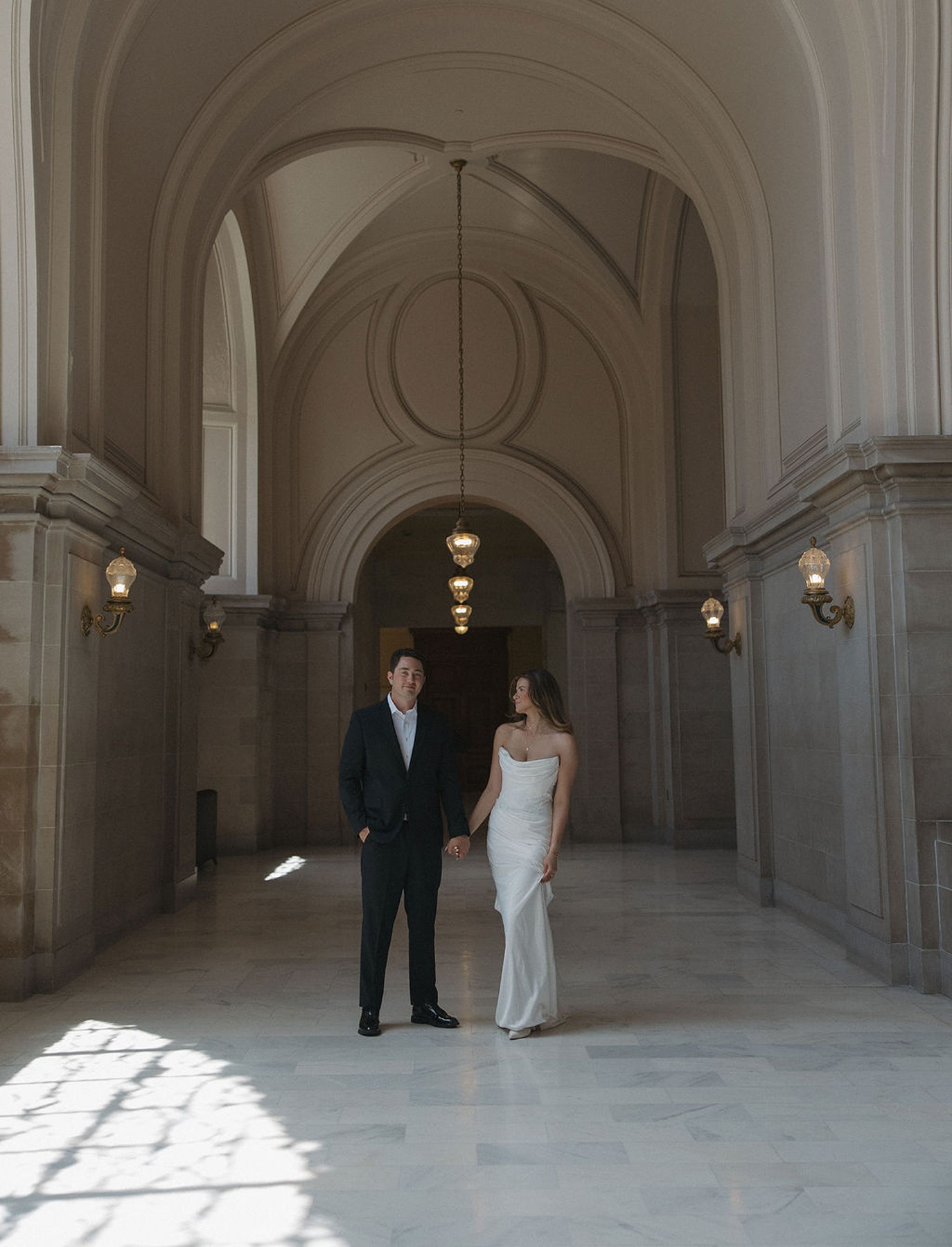 Couple posing in a city hall hallway before their elopement