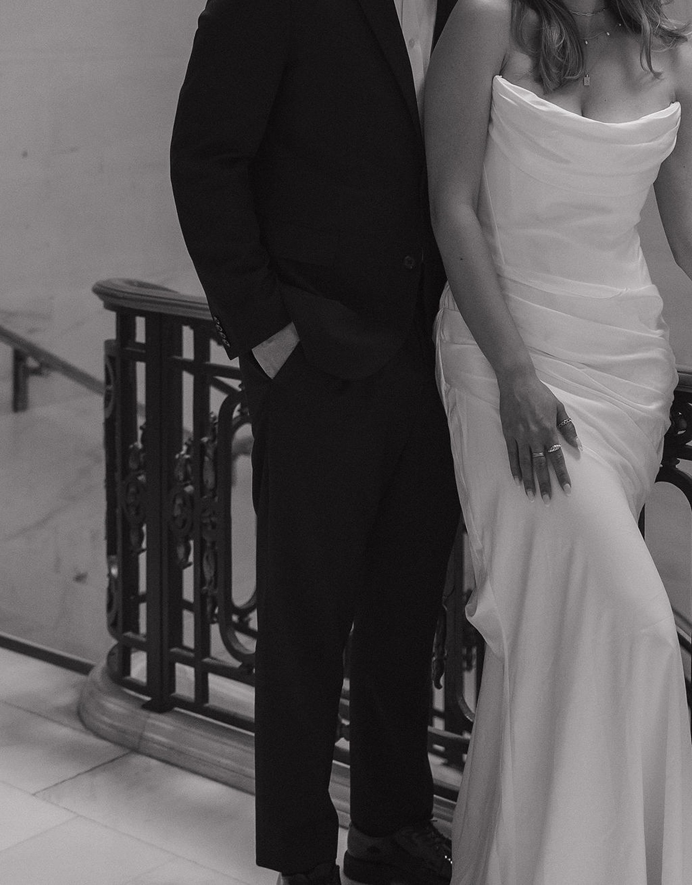 Editorial black and white wedding photo of couple's elopement outfits, a casual suit and a simple strapless satin wedding dress