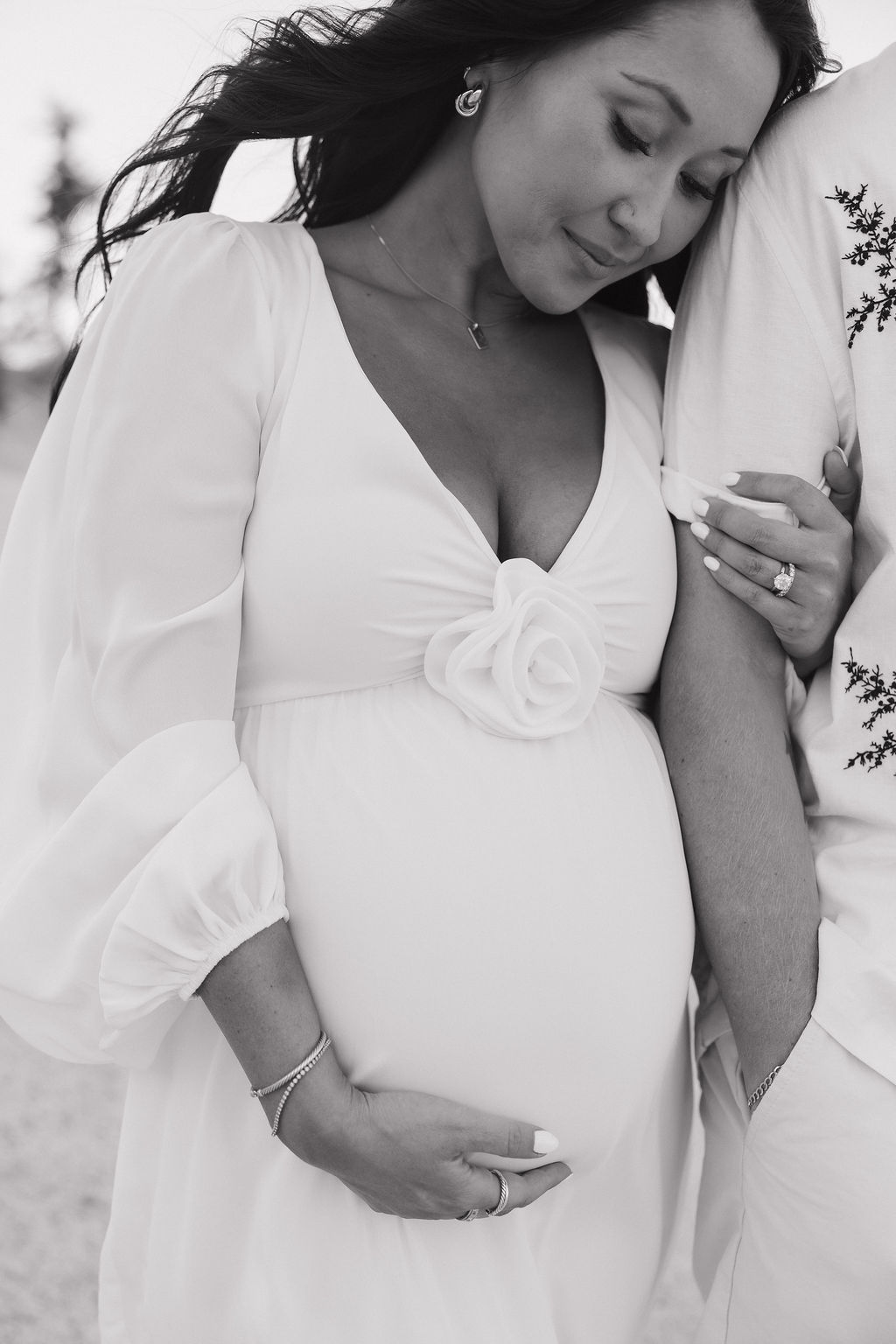 A black and white photo of mother holding her baby bump