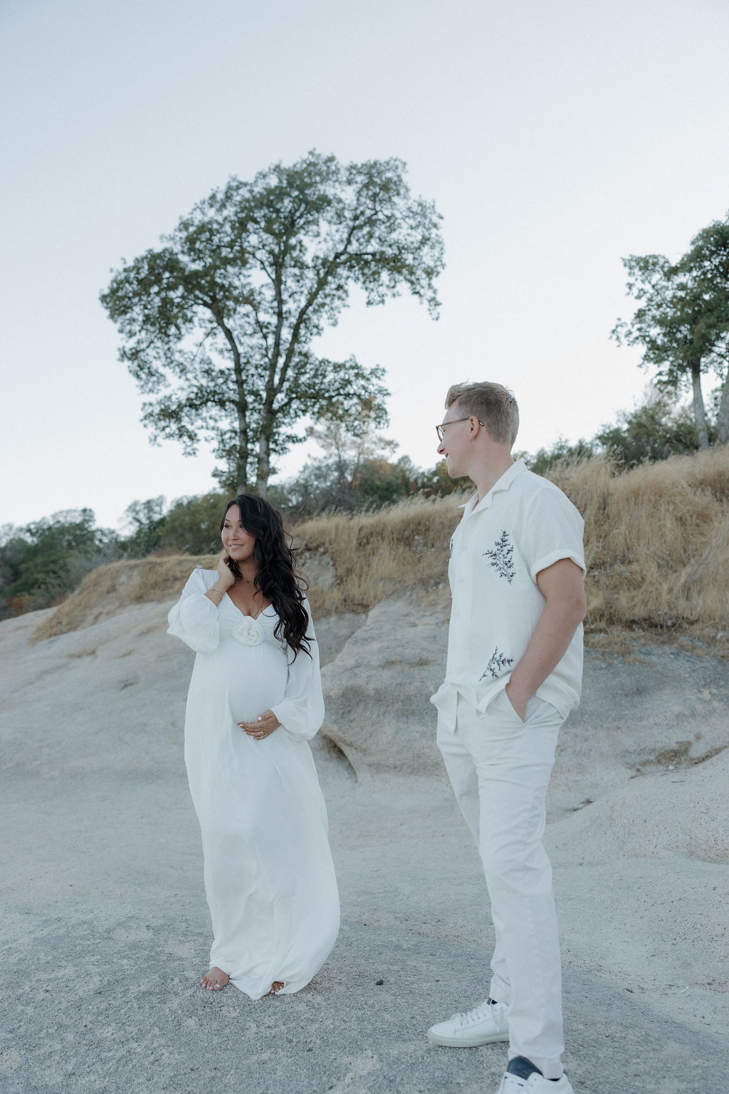 Man and woman standing to pose for their maternity photos
