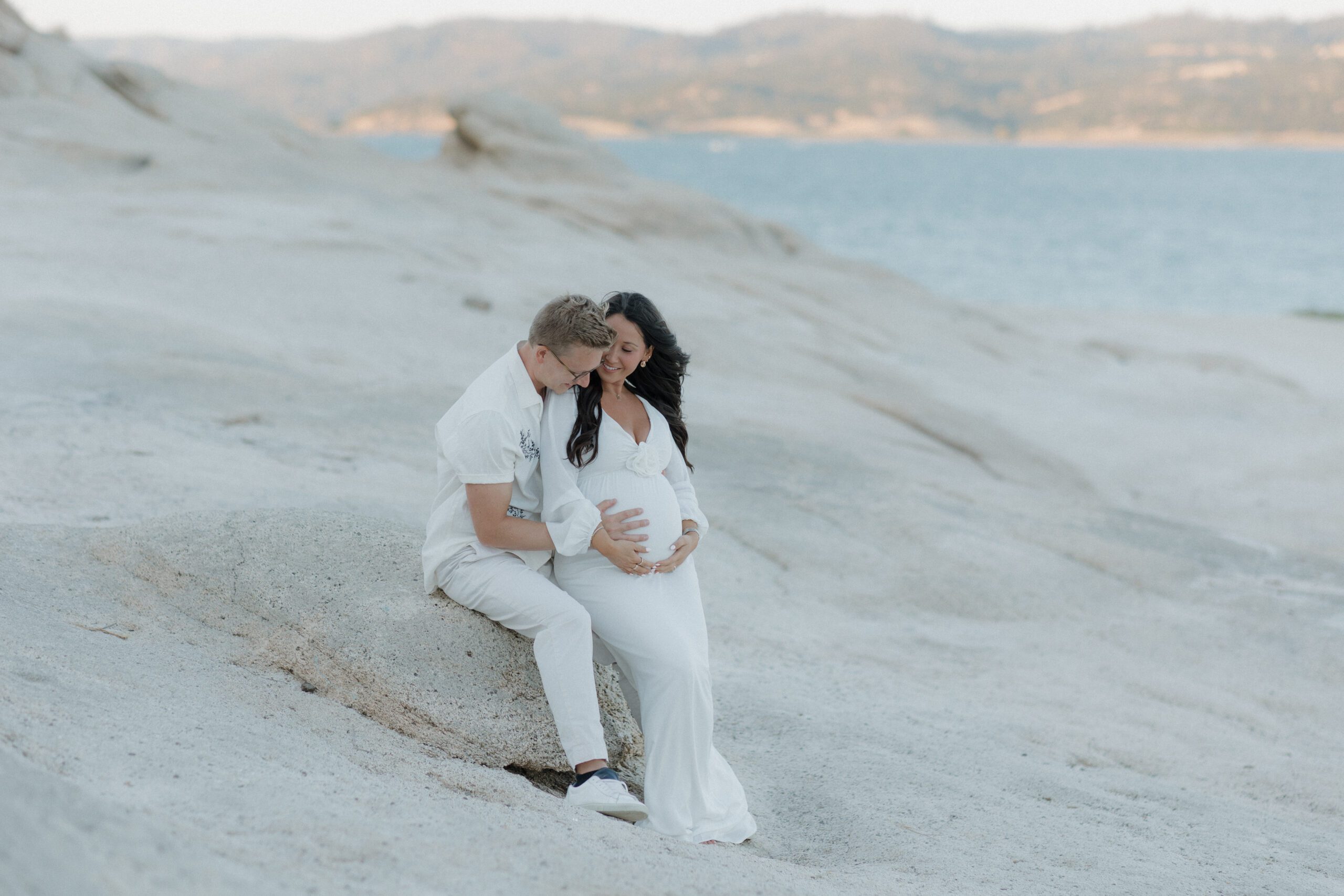 A man holding his wife's baby bump during their maternity photo session