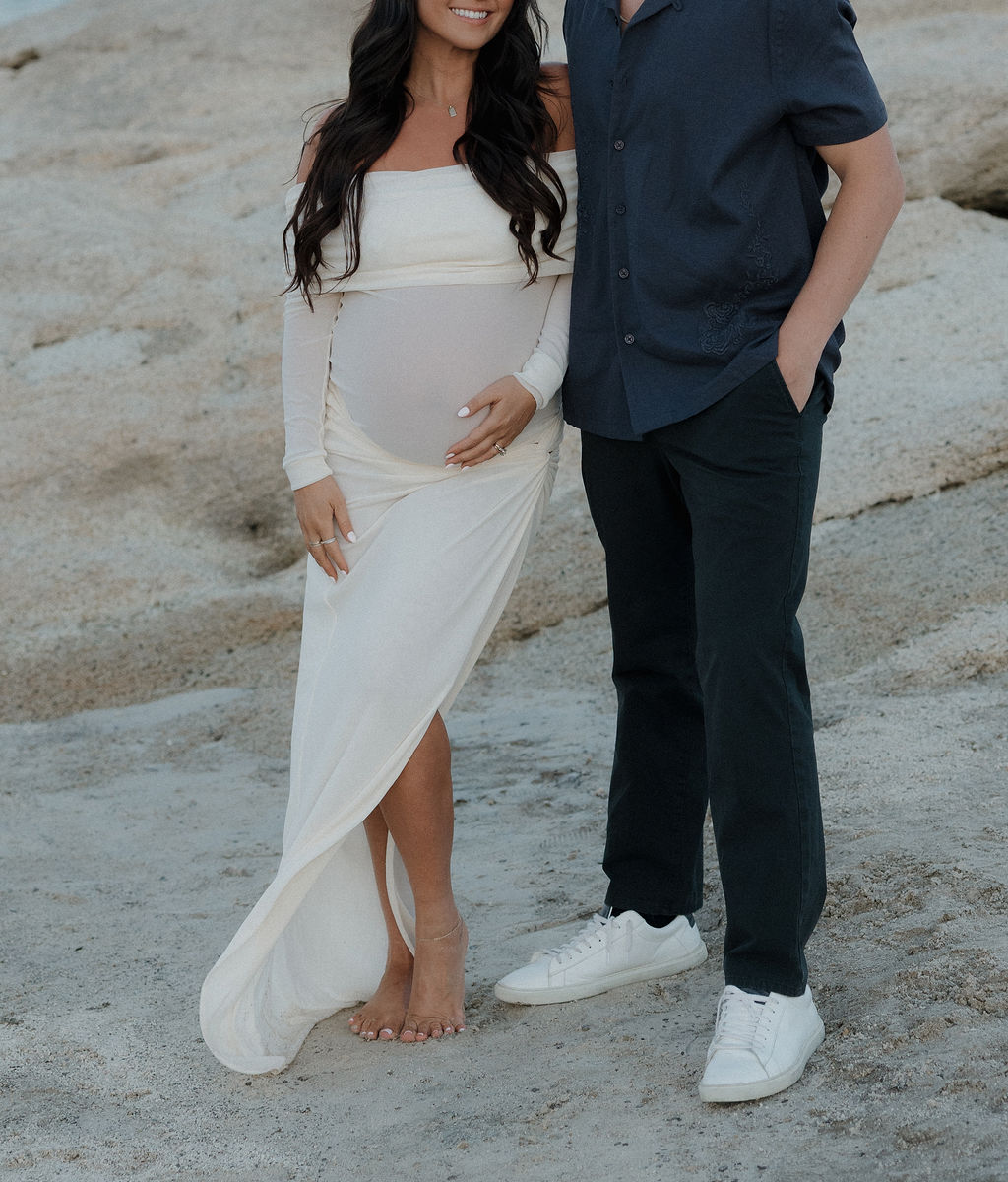 A photo of man and woman's maternity photoshoot outfits, a white dress and a navy shirt with black pants