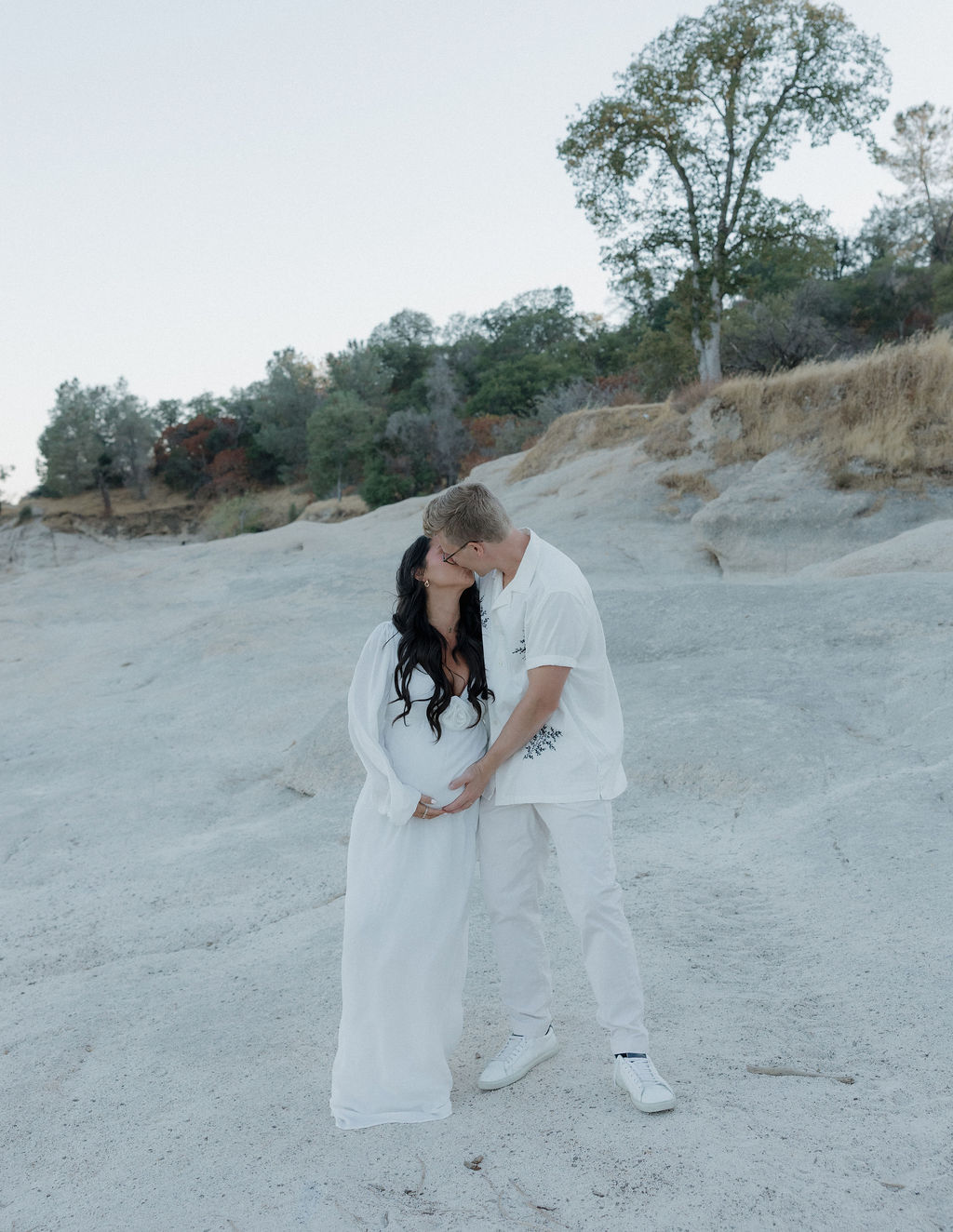 Mother and father kissing during maternity photoshoot