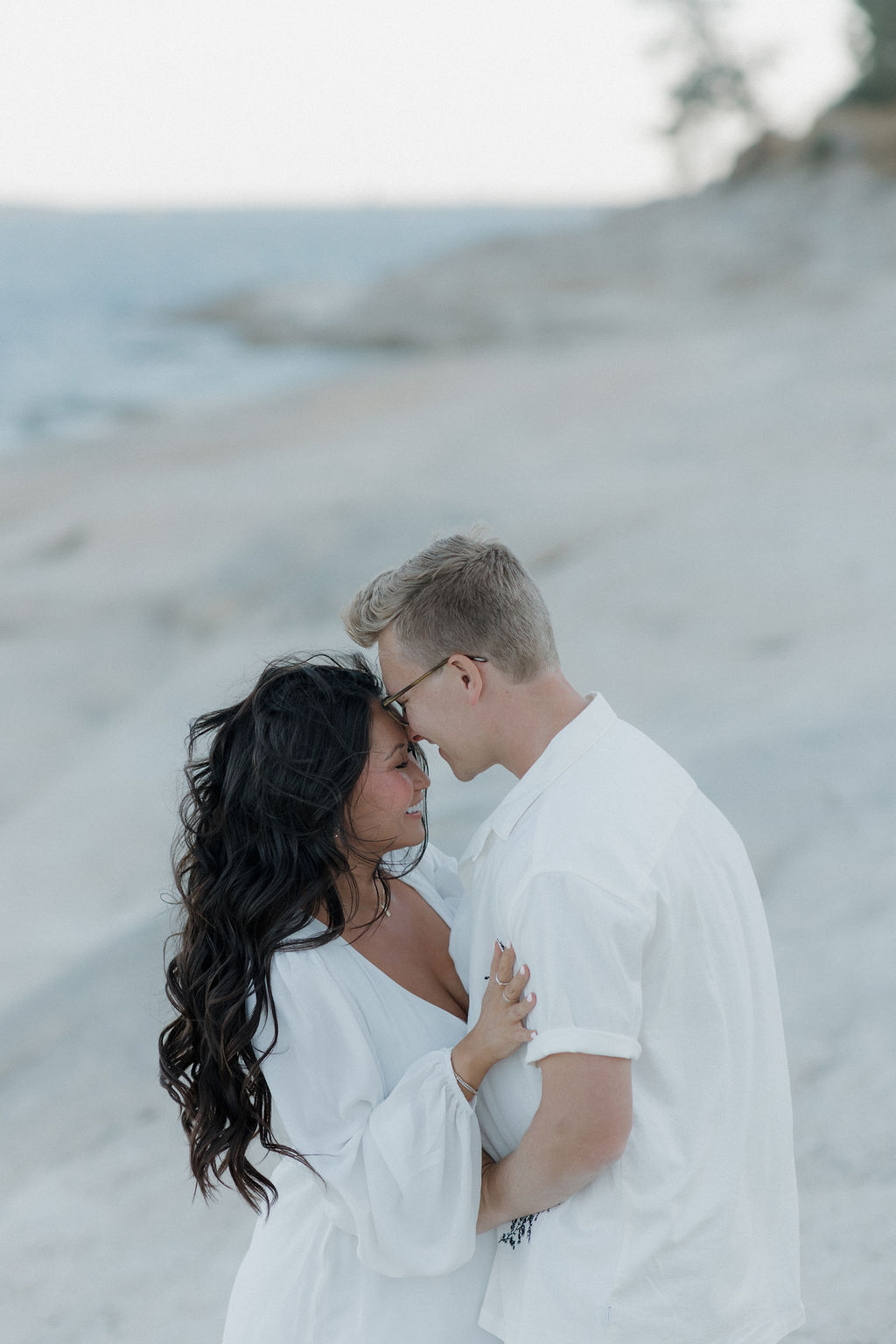 A couple leaning in for a kiss during their maternity photoshoot