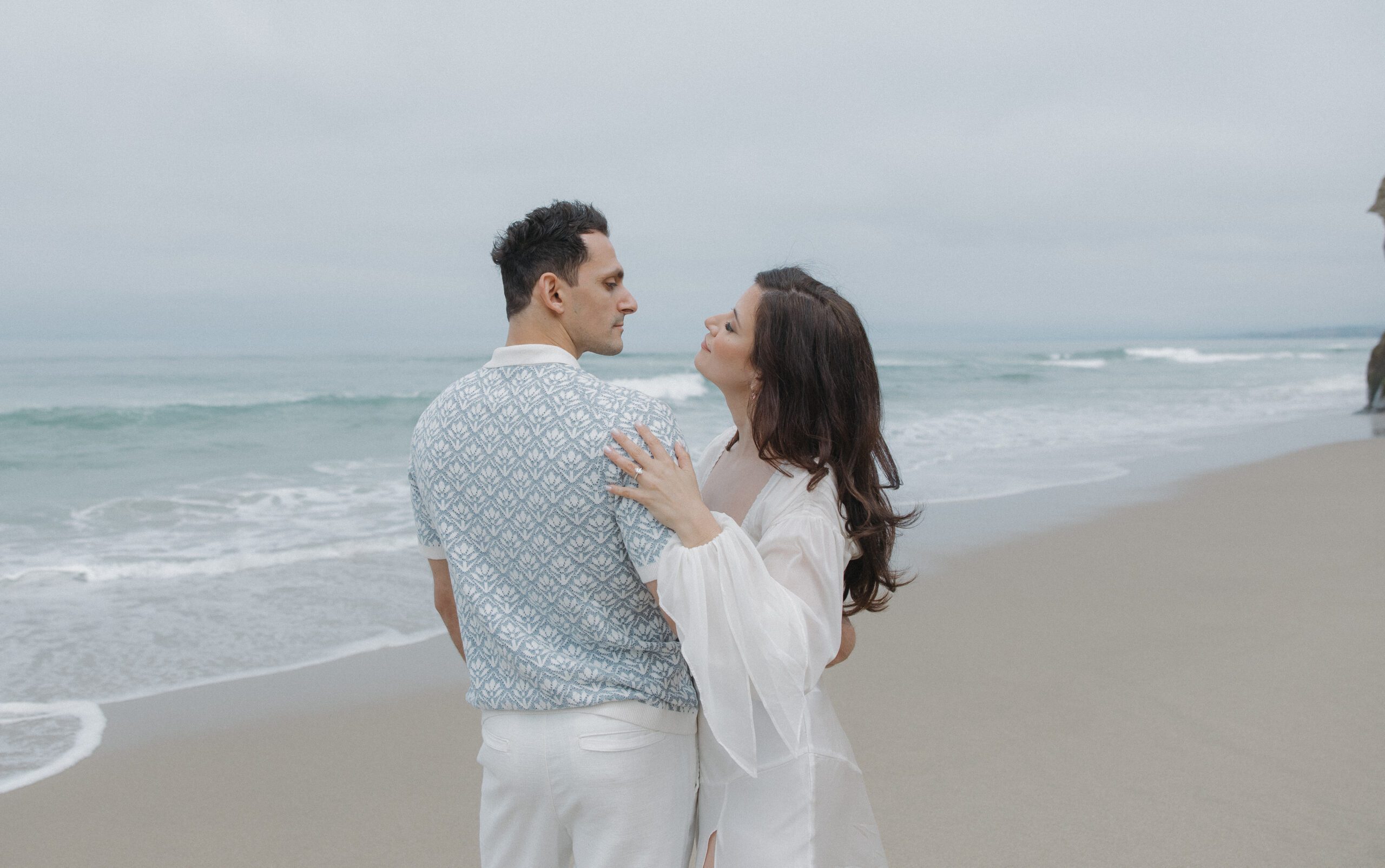 Couple leaning in for a kiss on the beach