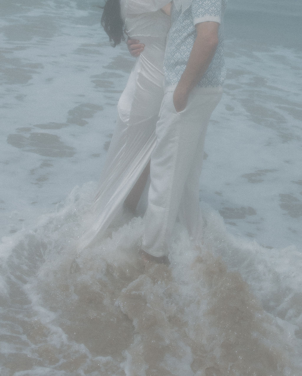 Editorial photo of couple hugging in the ocean with a film-inspired effect