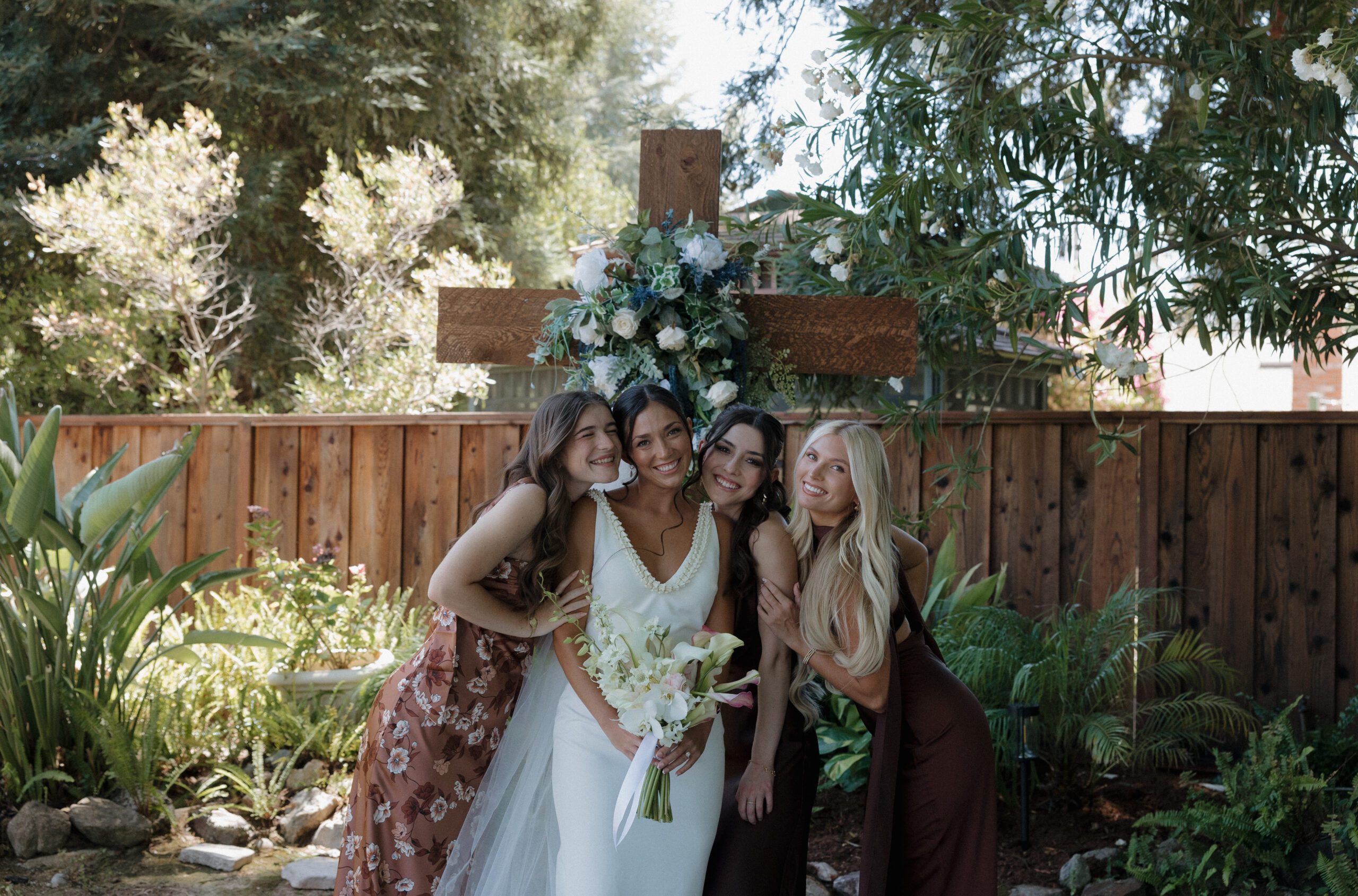 Bridal party photo where bridesmaids are leaned in to hug bride