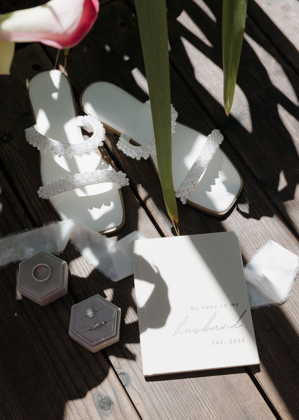 Wedding flat lay photo with wedding shoes, rings, and a vow book