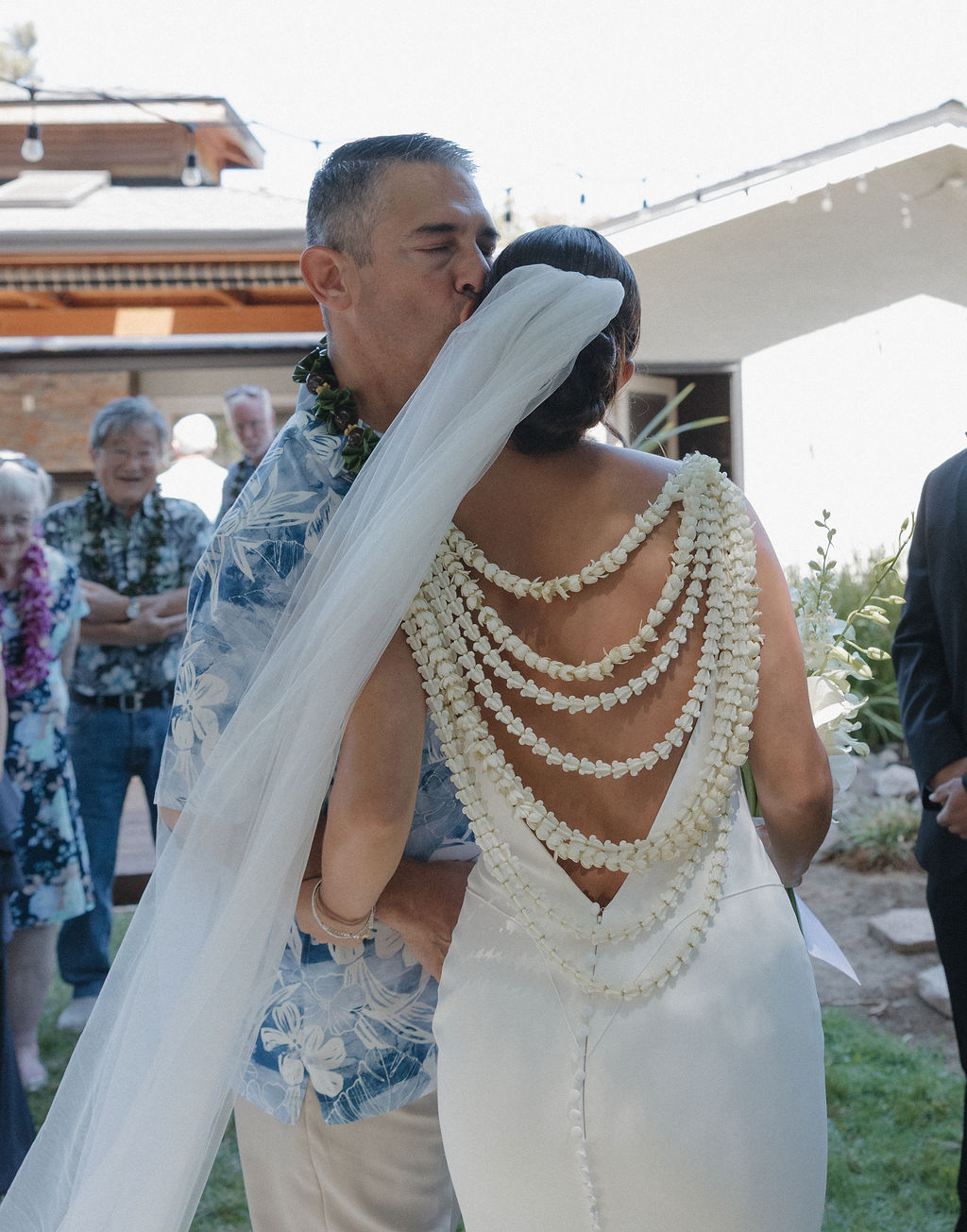 Bride's father kissing her forehead after walking her down the aisle