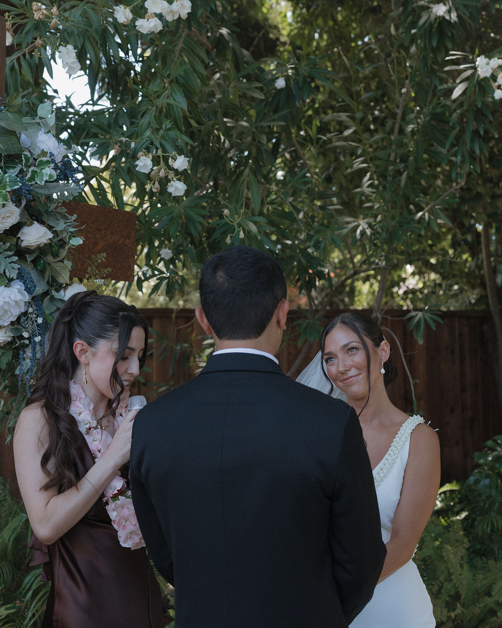 Candid wedding photo of bride smiling at groom during the wedding ceremony