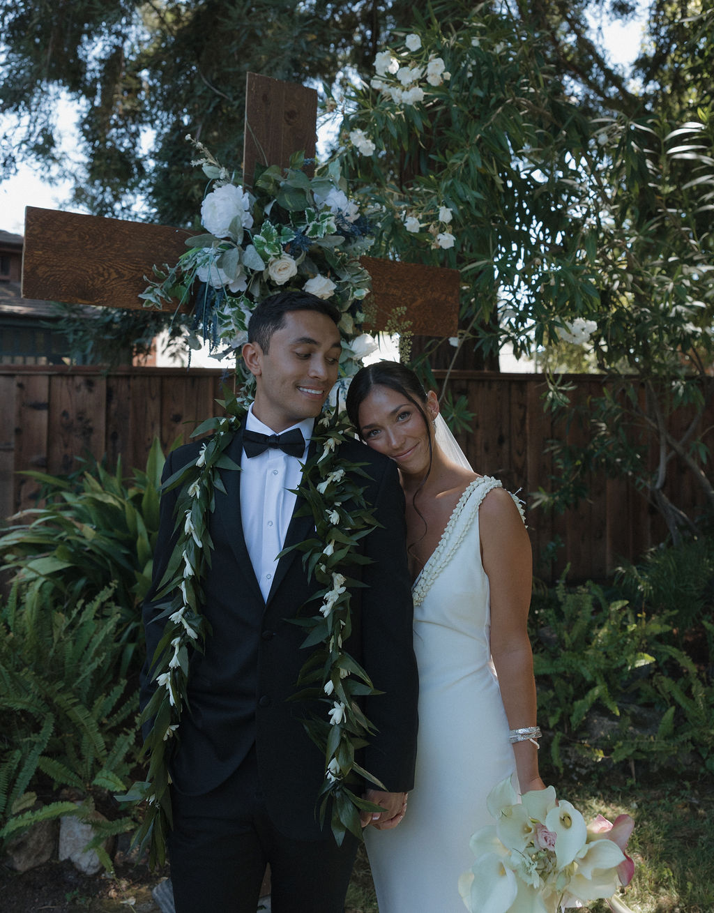Bride leaning her head on groom's shoulder during wedding portraits