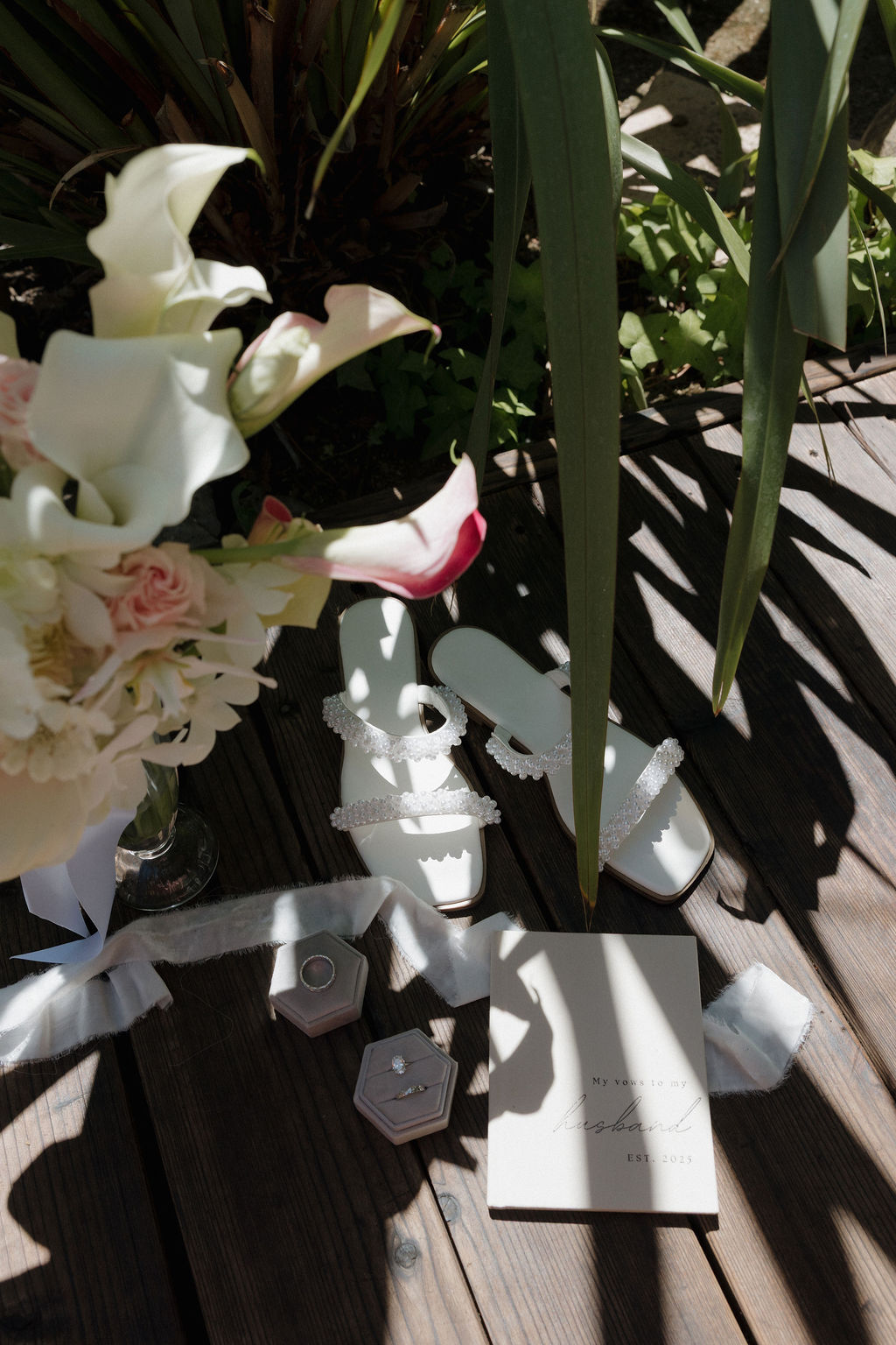 Wedding flat lay photo of wedding shoes, wedding flowers, wedding rings, and wedding invitations