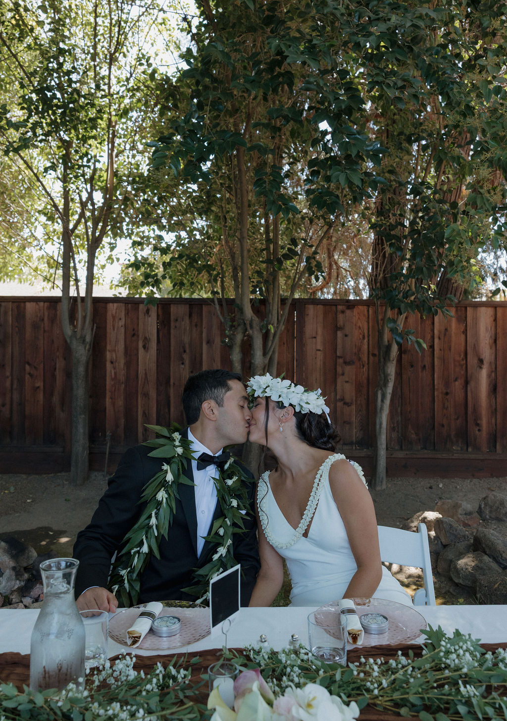 Bride and groom kissing at wedding sweetheart table