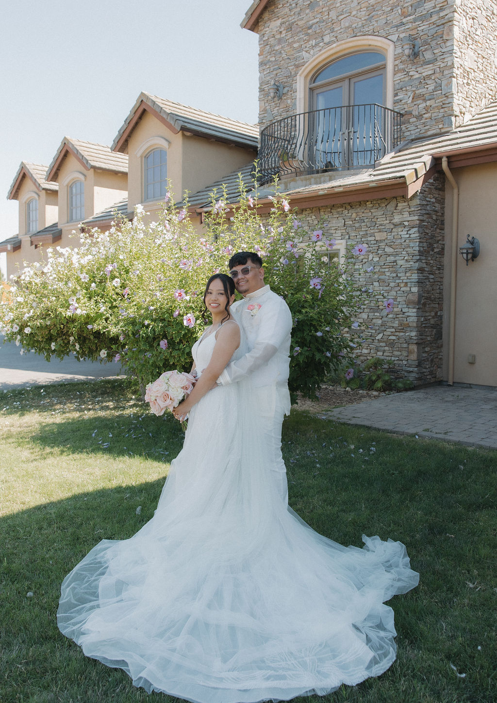 Bride and groom posing for portraits in front of the estate wedding venue