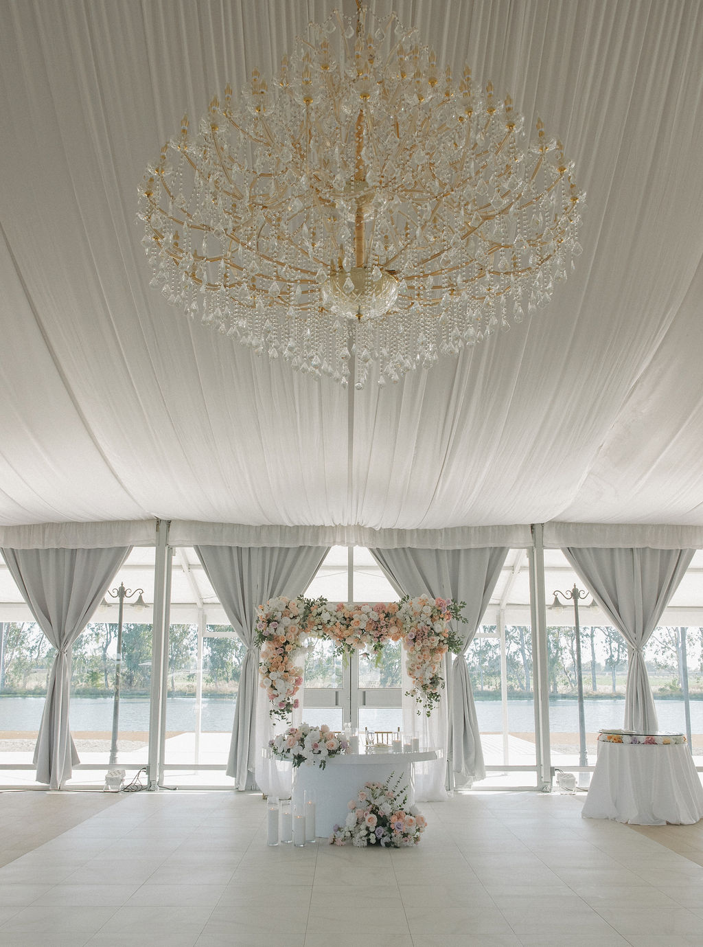 Wedding sweetheart table ideas set up underneath a tent with tall windows