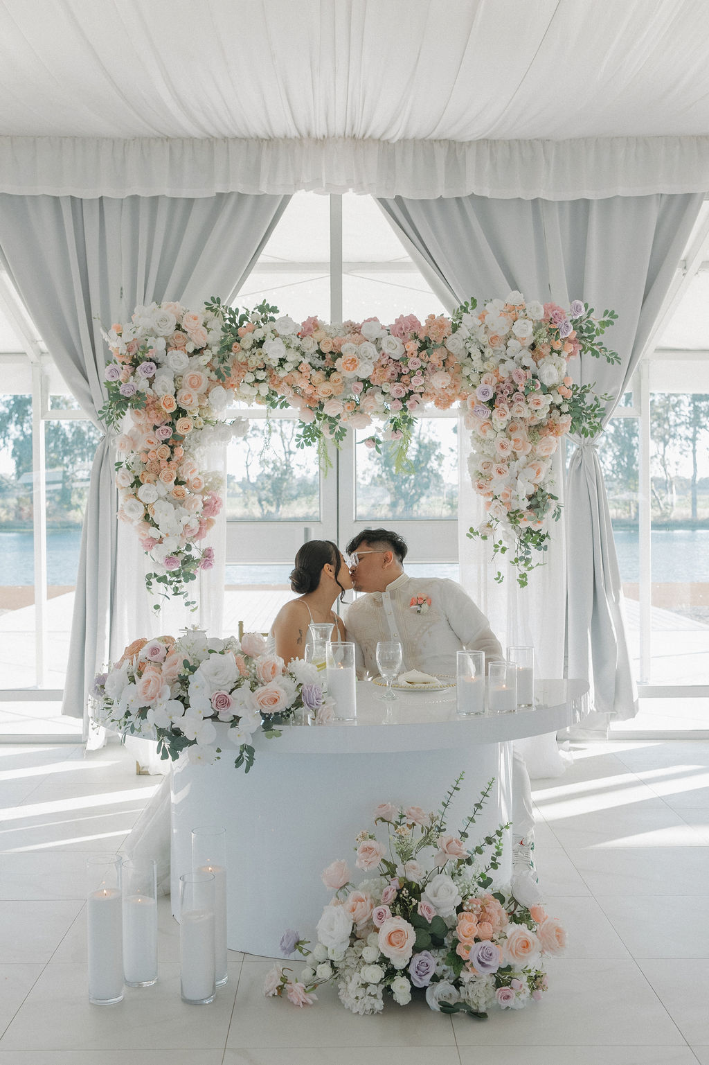 Bride and groom kissing at their sweetheart table