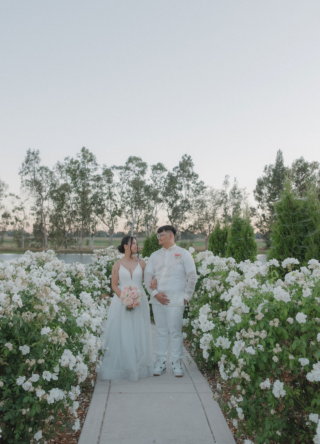 Bride and groom walking through the gardens at Lakeview Estates