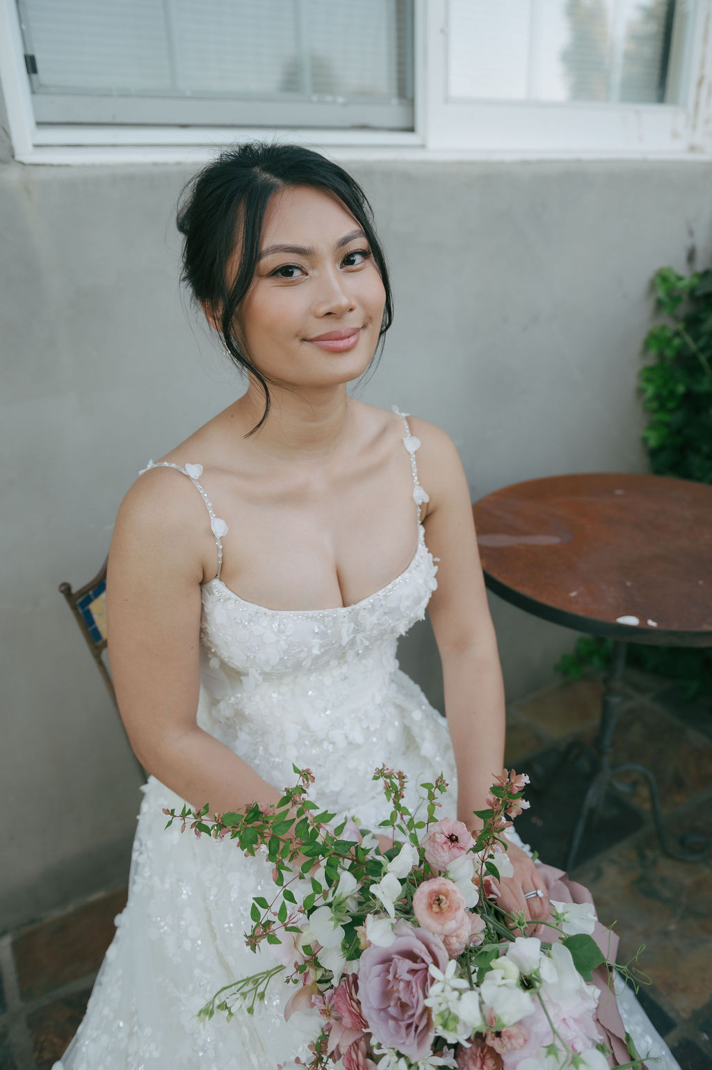 Bride smiling at the camera, showing off her wedding makeup