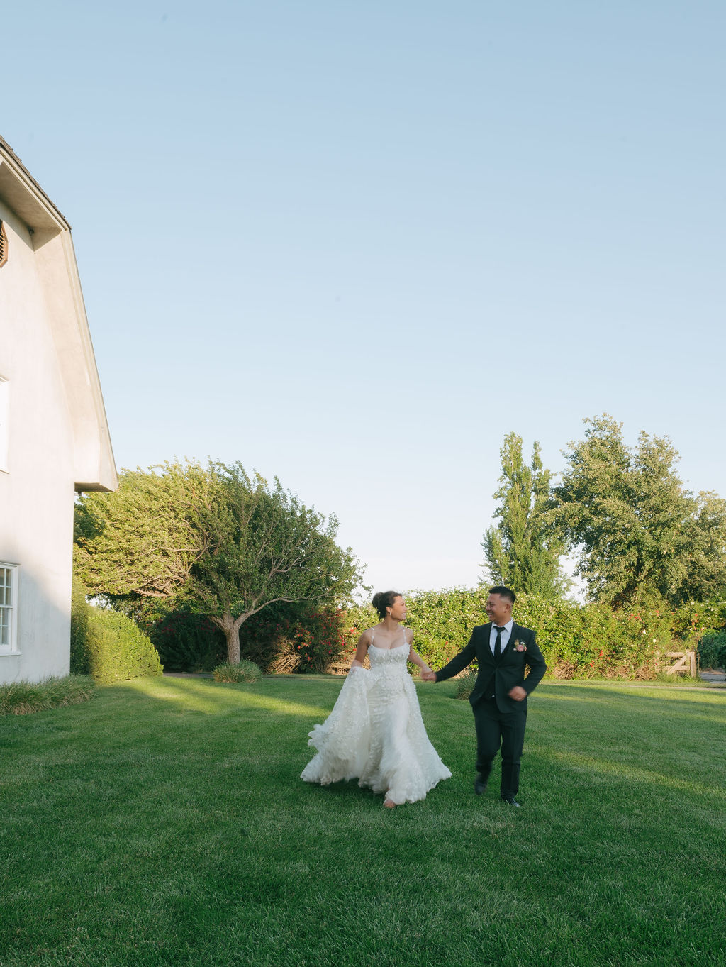 Bride and groom running across the lawn at Cavaignac Estate during wedding portraits