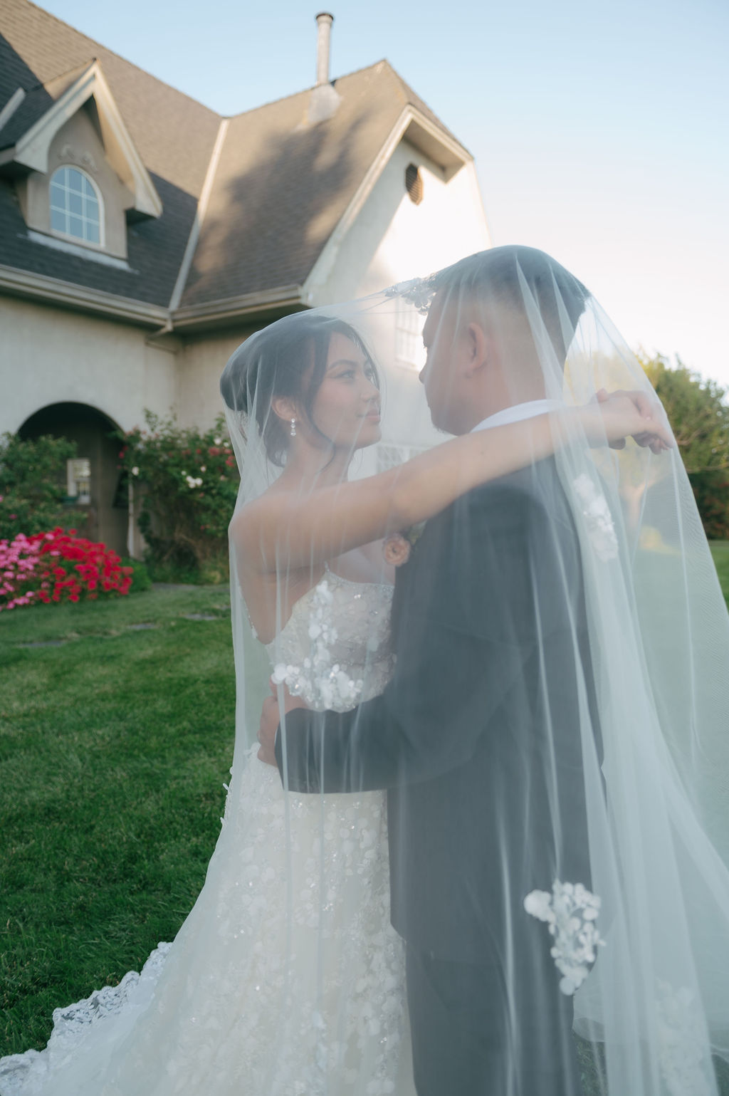Bride and groom looking at each other under bride's veil