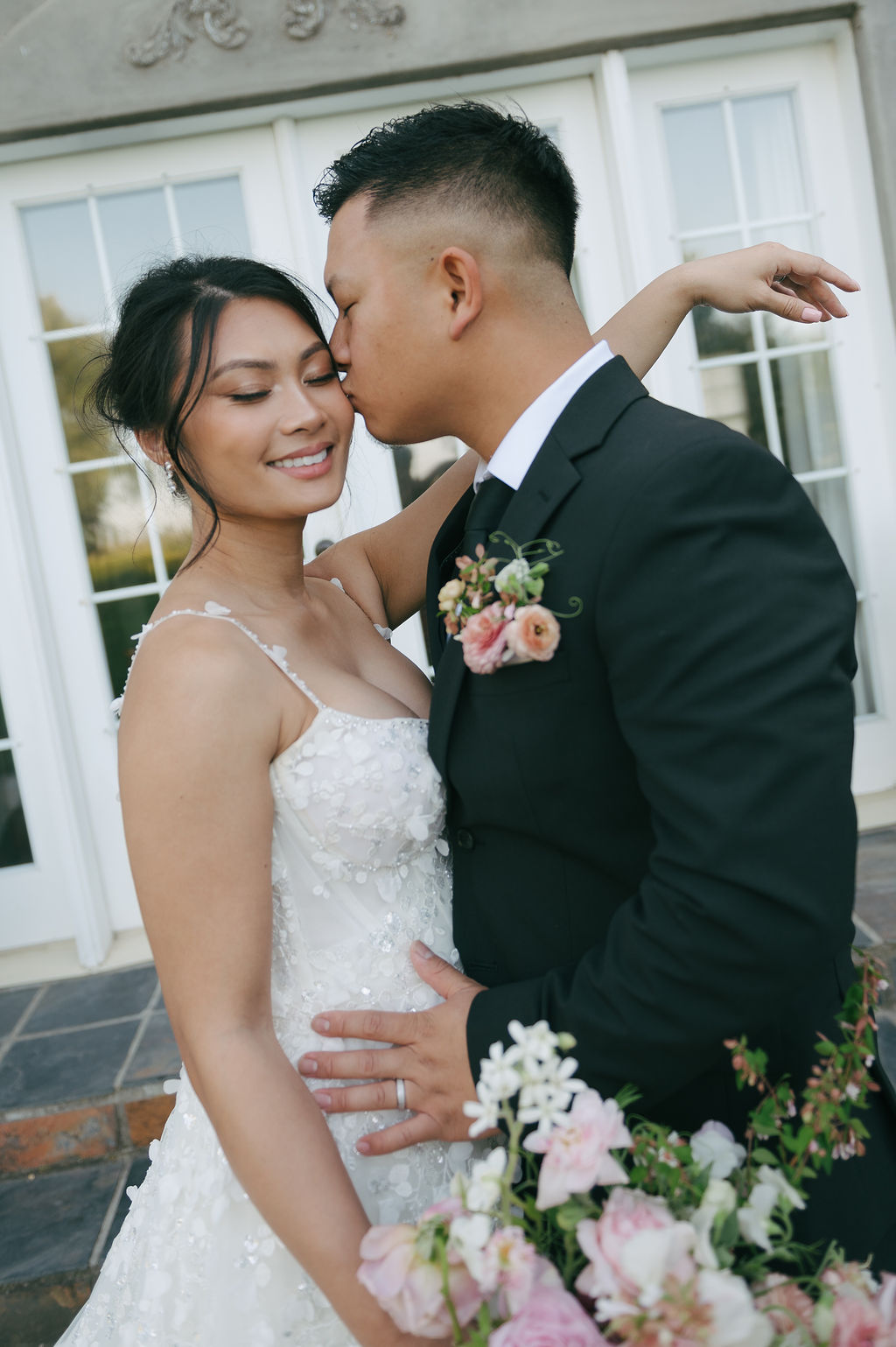 Groom kissing bride on the cheek
