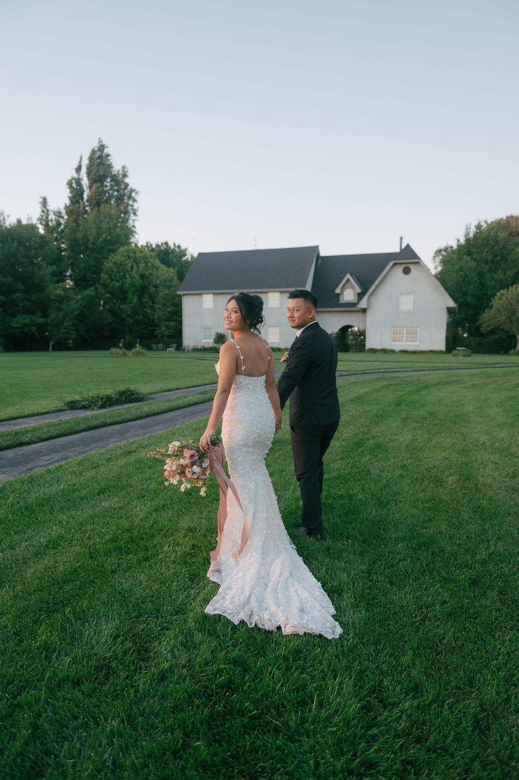 Couple walking across the lawn during a post-wedding photoshoot