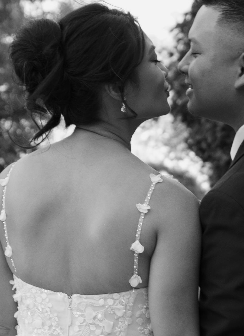 Bride with her hair in an updo leaning in to kiss her husband