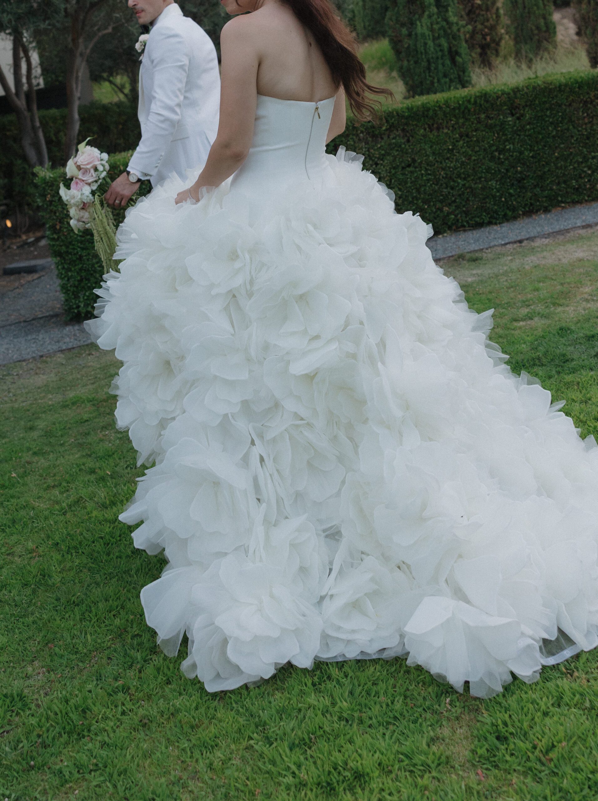 Editorial wedding photo of bride and groom walking away from the camera