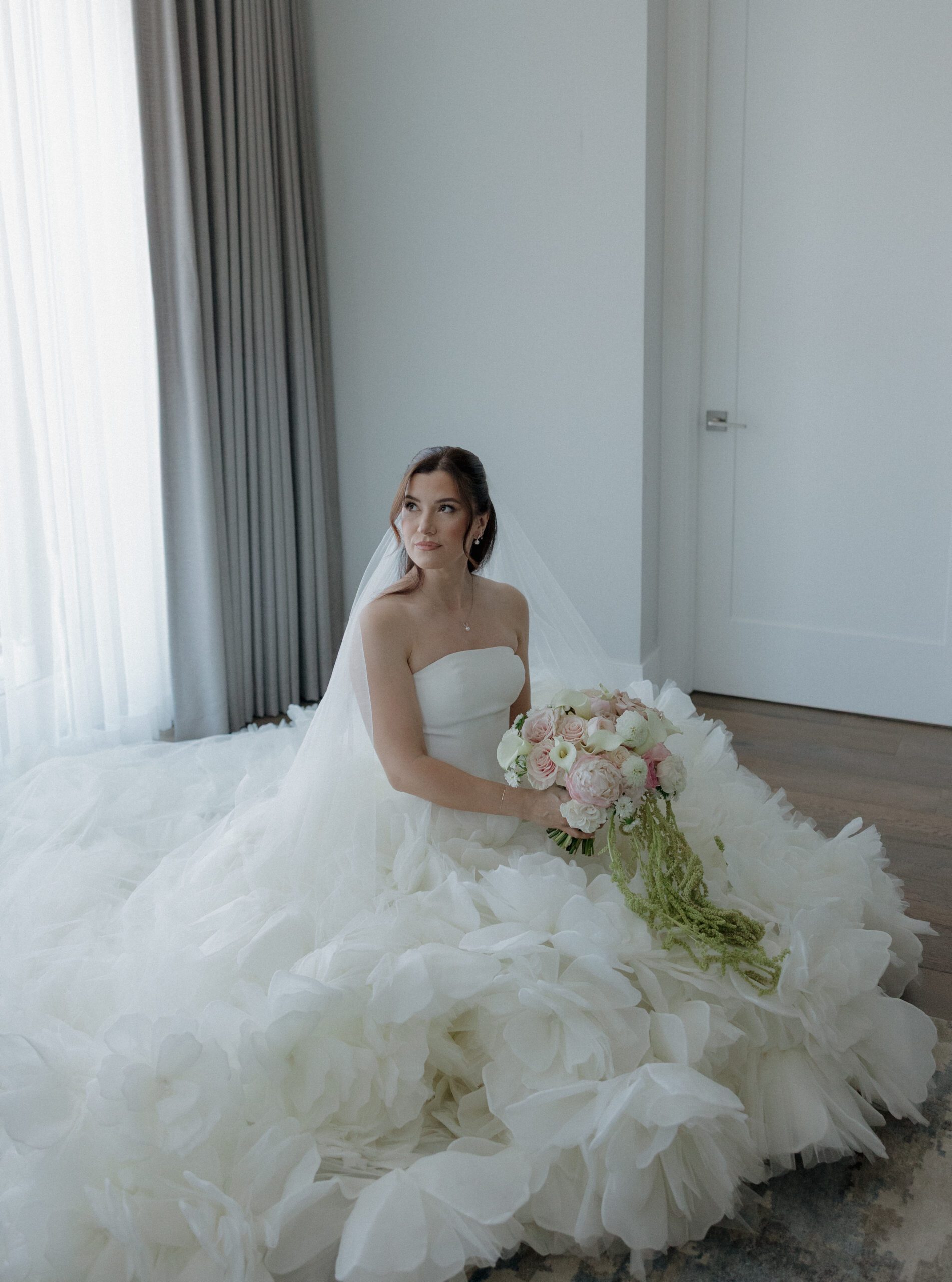 A bridal portrait of bride sitting in her ballgown wedding dress in her wedding getting ready photos