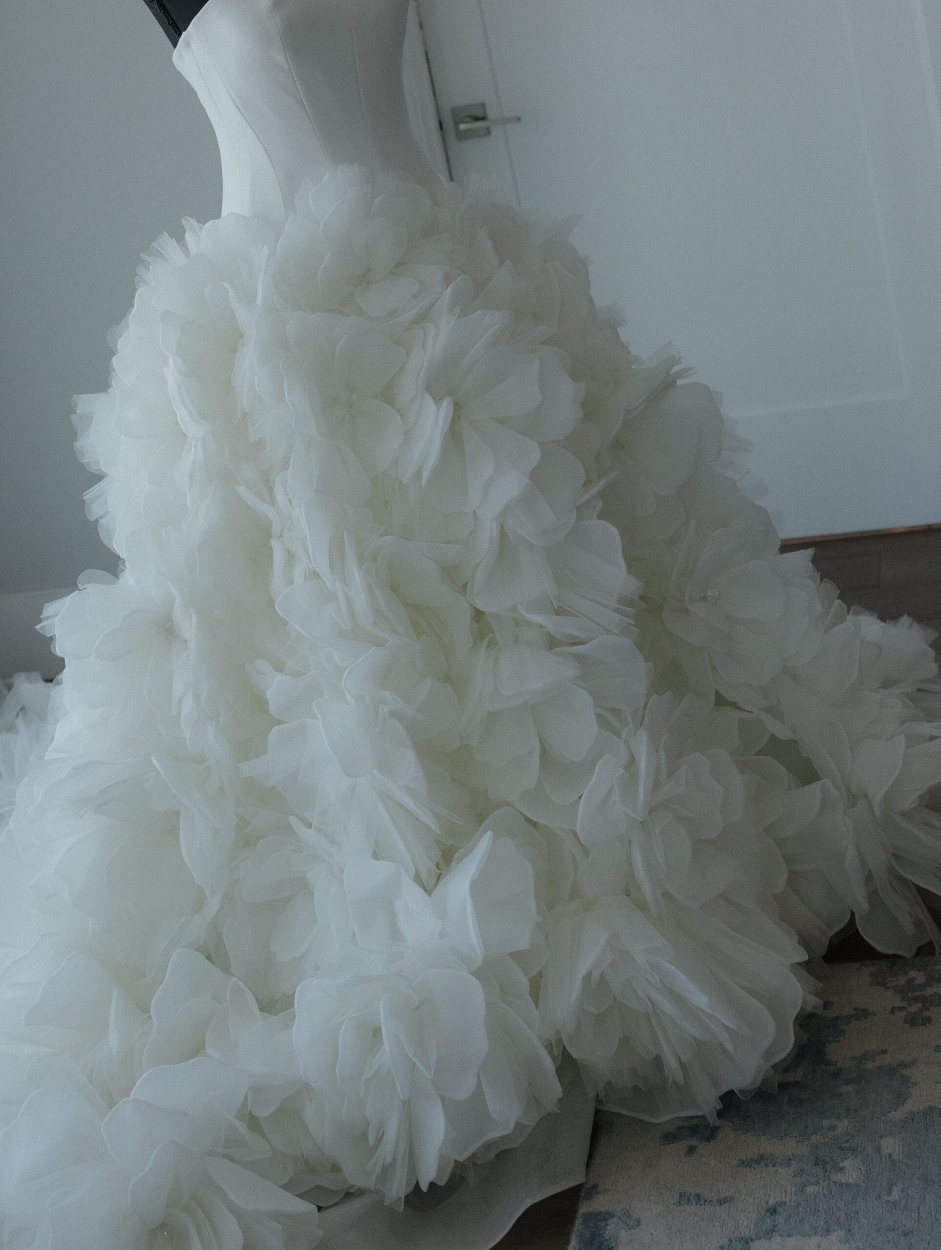 A Nicole + Felicia ballgown wedding dress on a mannequin from wedding getting ready photos