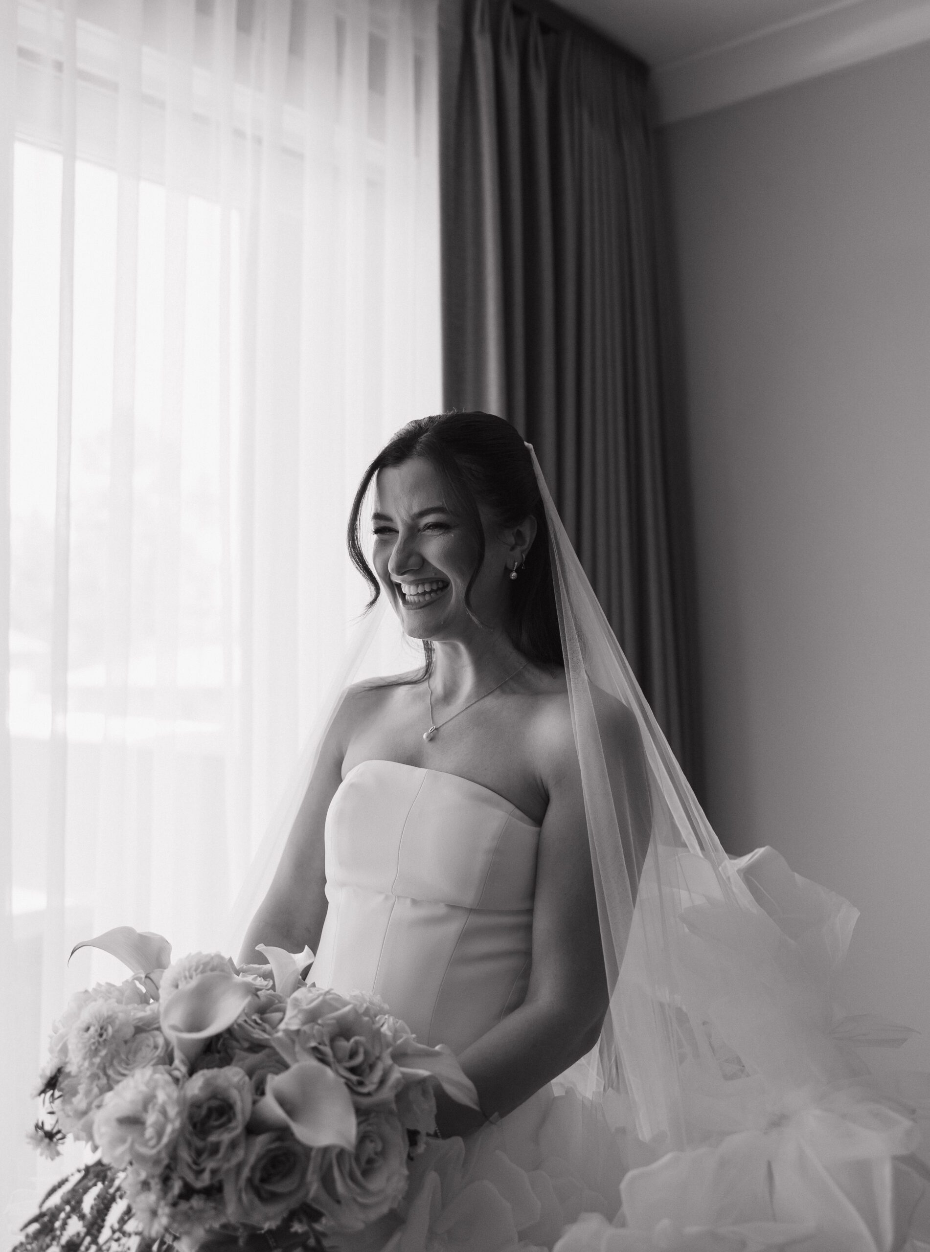 Candid photo of bride laughing while getting ready