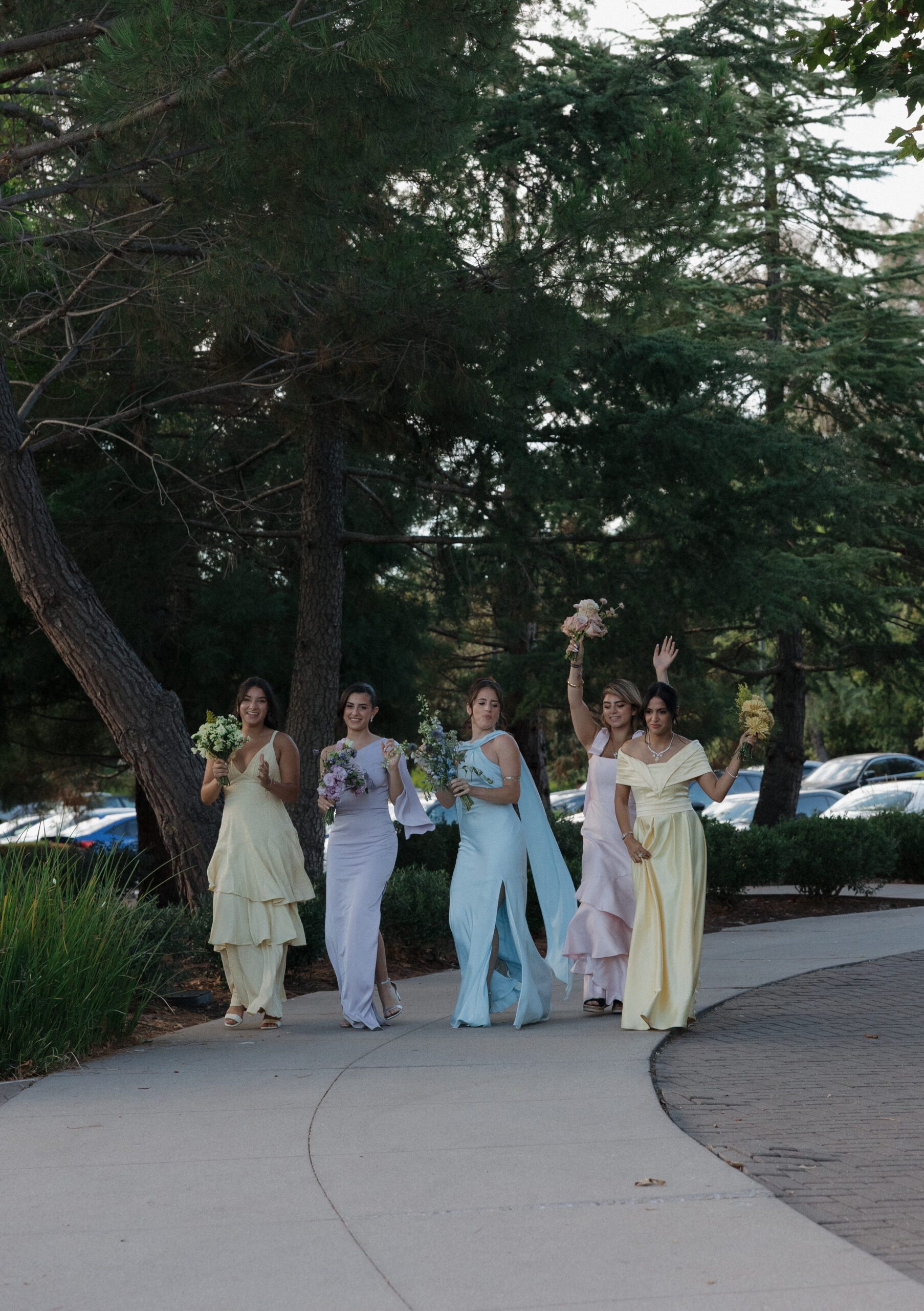 Bridesmaids entering the reception in pastel bridesmaid dresses
