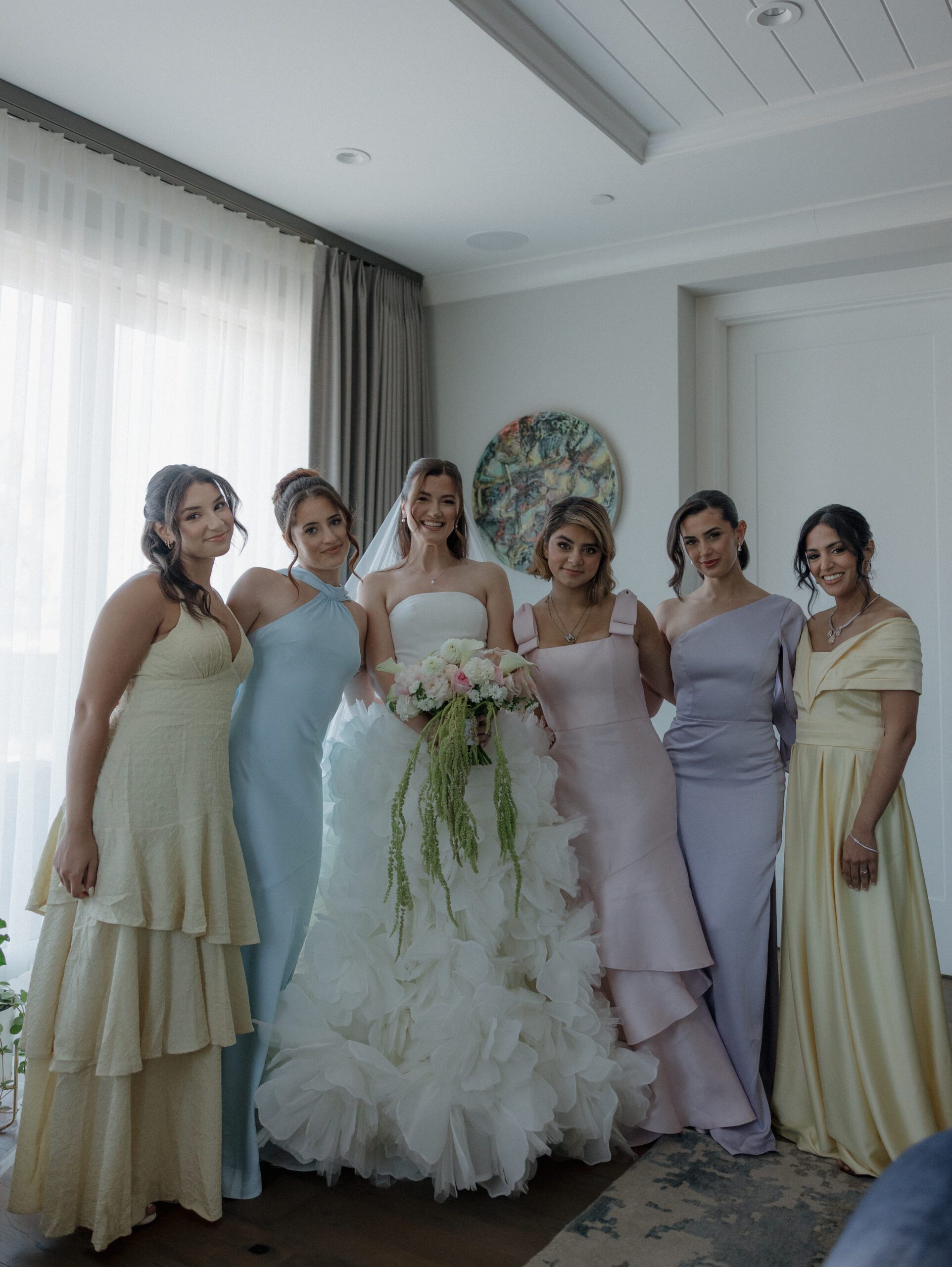 Bride posing with bridesmaids in the wedding getting ready suite