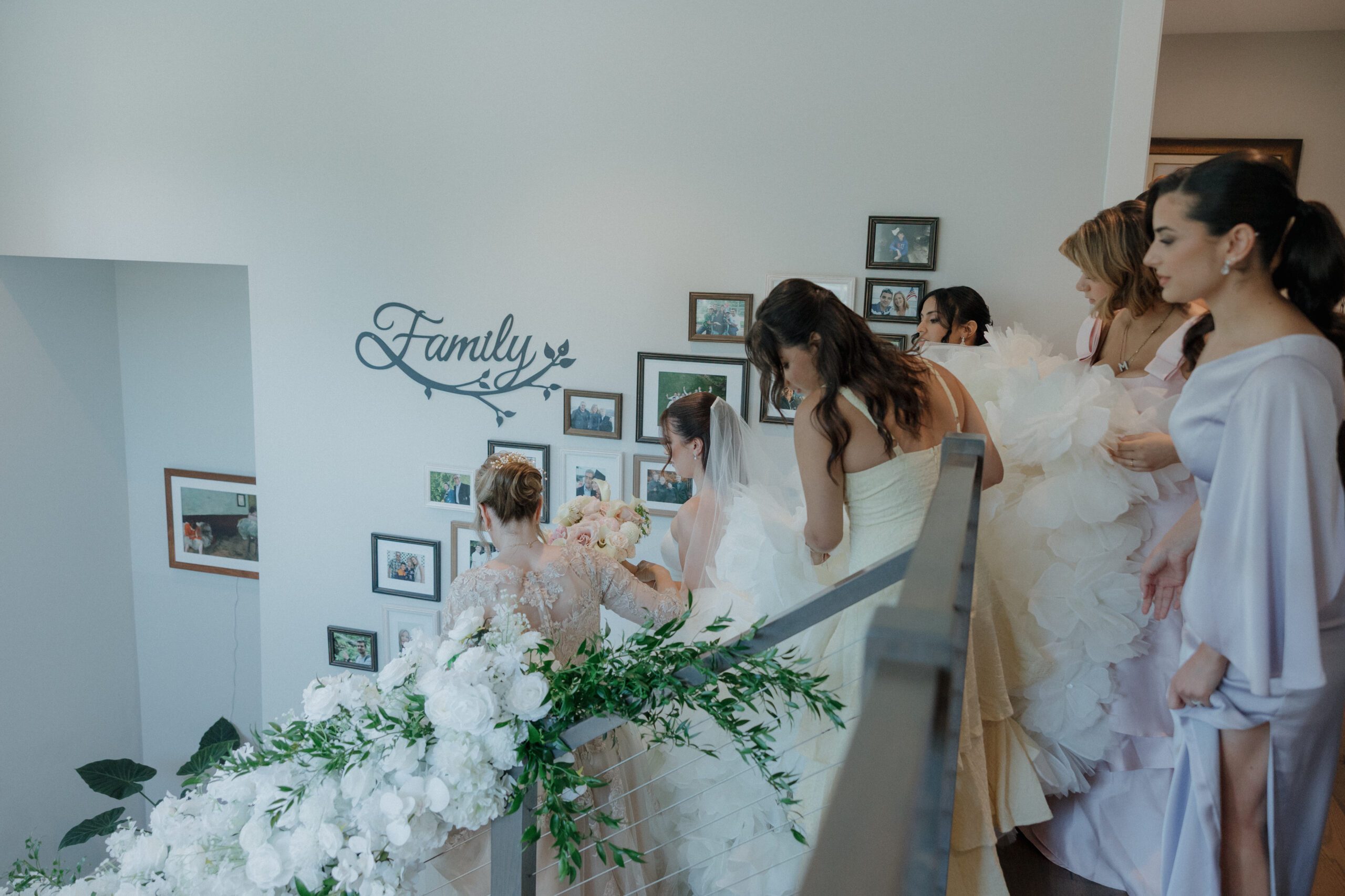 Bride and bridesmaids walking down the stairs after getting ready at family home