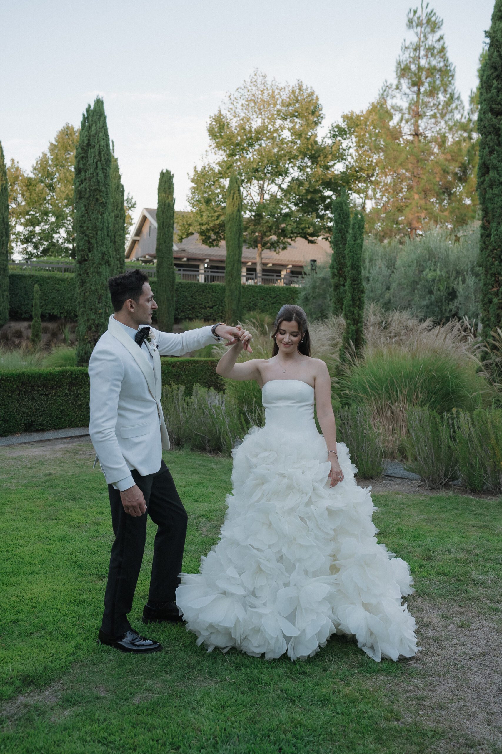 Groom spinning bride on a European lawn at an Italian-inspired wedding