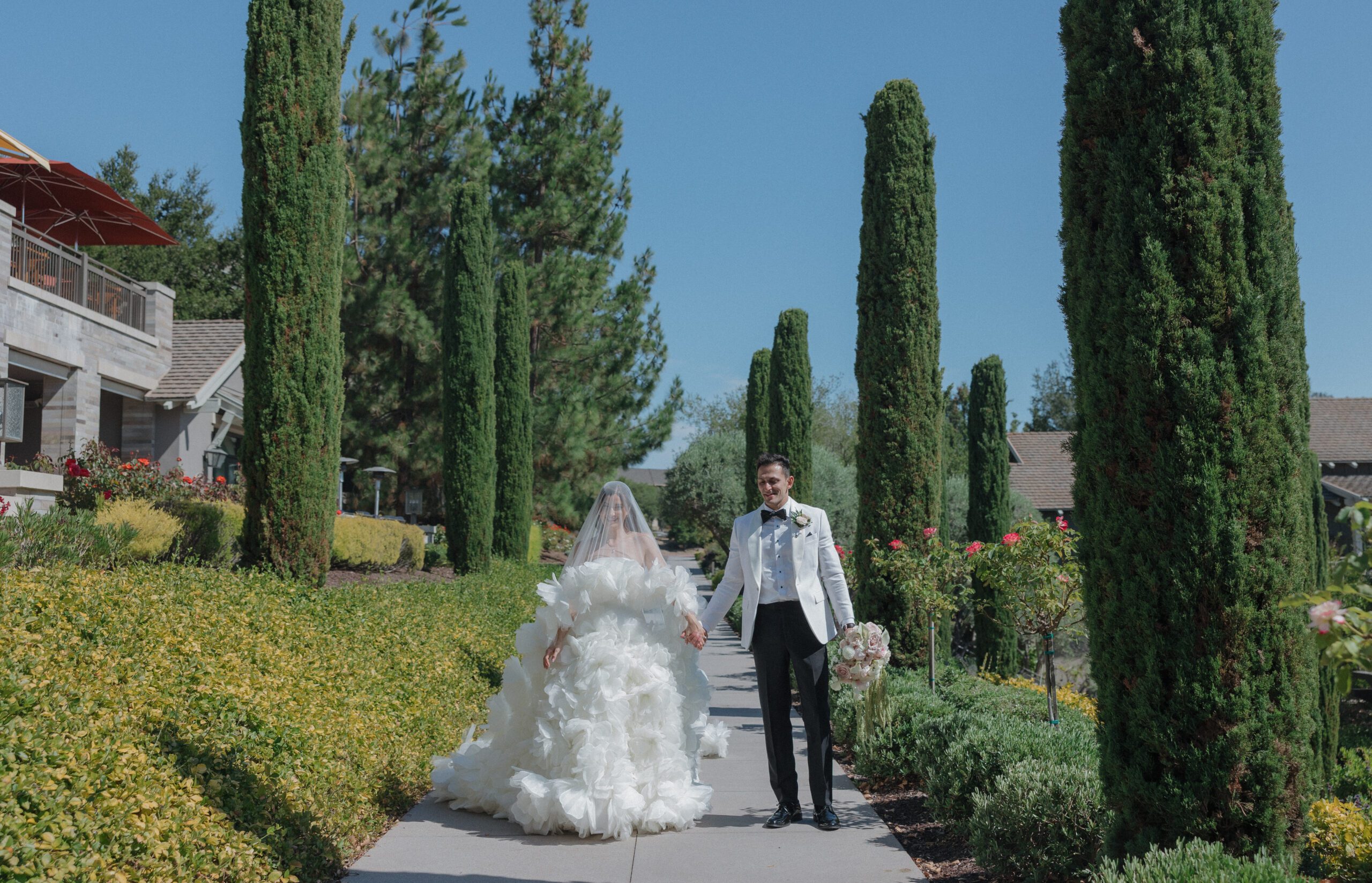 Bride and groom walking through garden at wedding