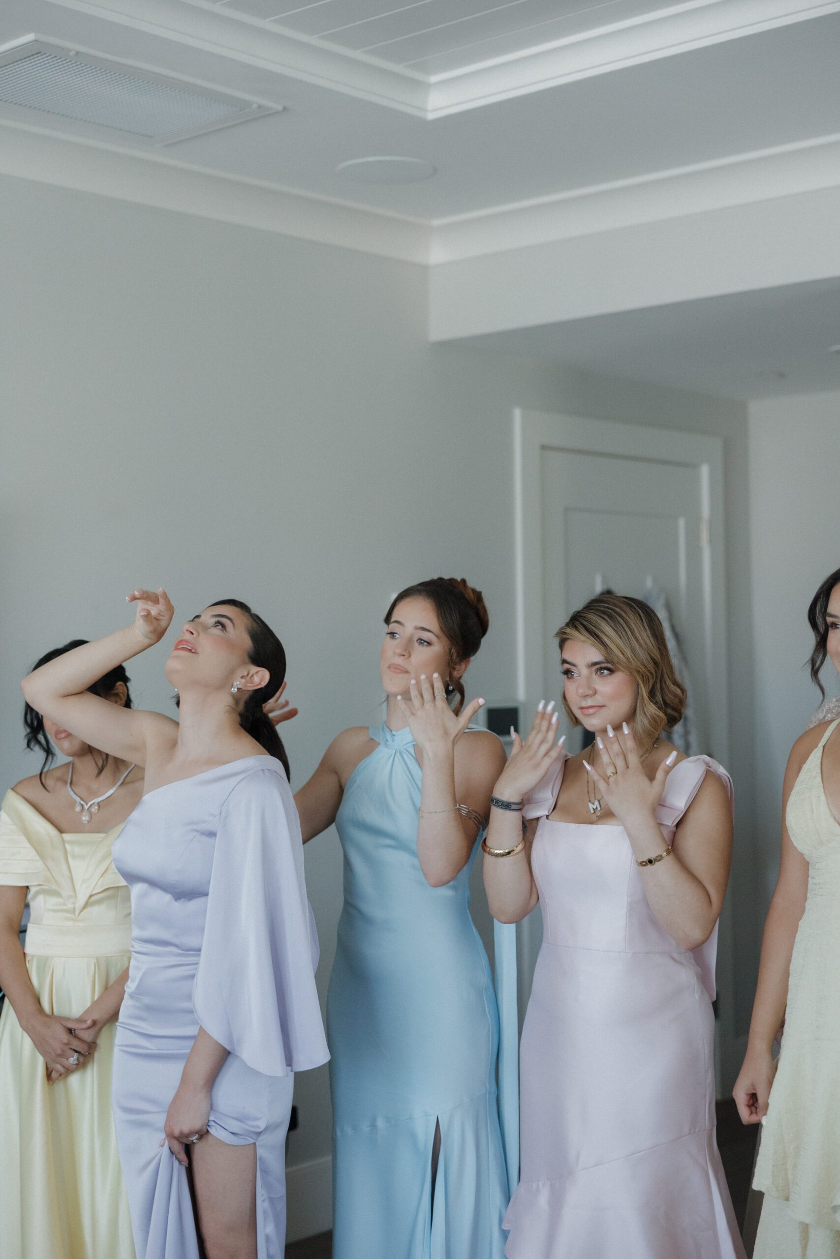 Candid wedding photo of bridesmaids crying while bride gets ready