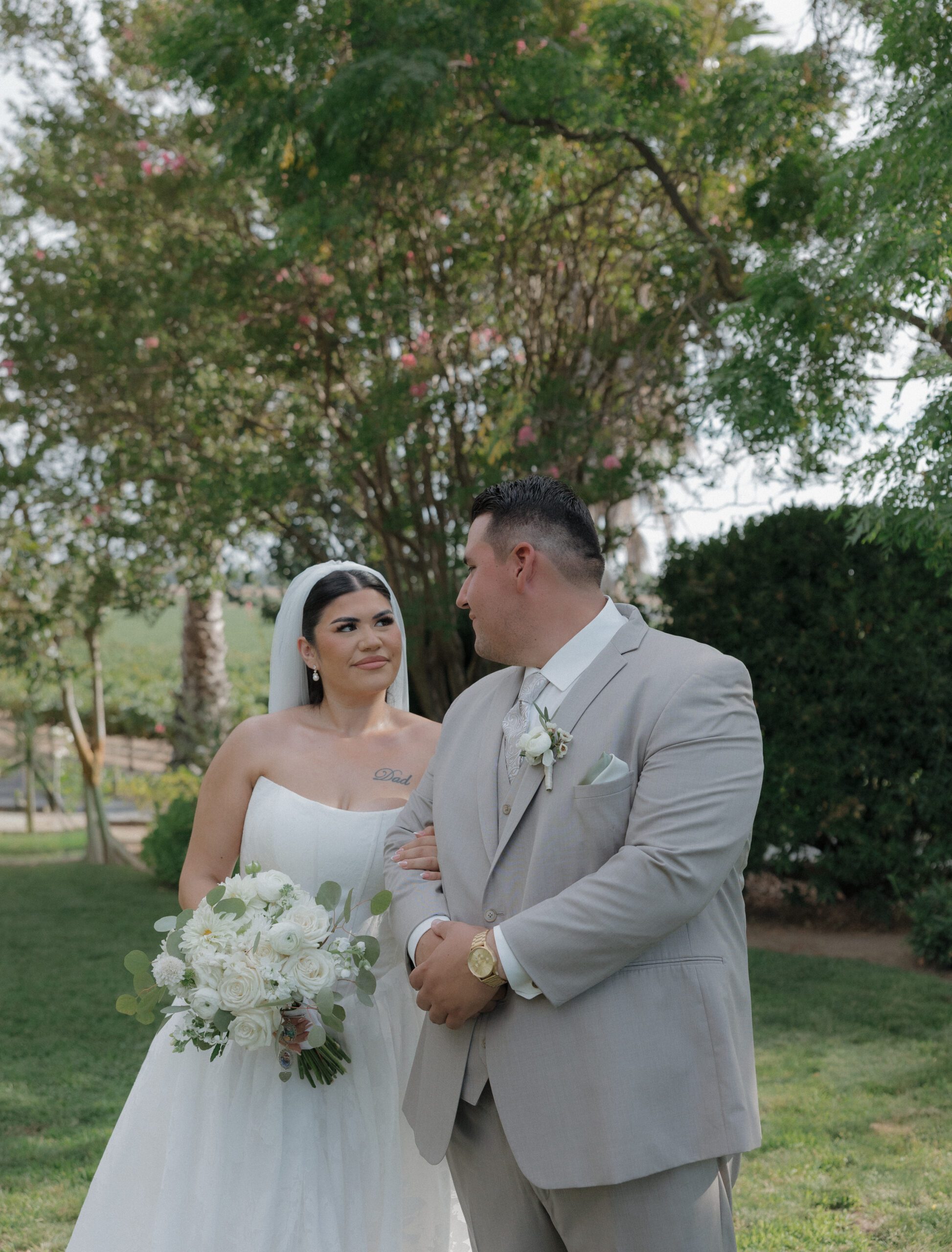 Outdoor wedding photo of bride and groom looking at each other lovingly