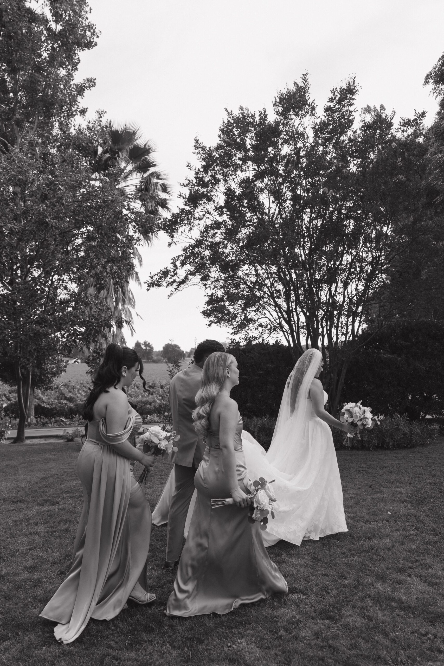 Bride walking with her bridal party in candid wedding photo