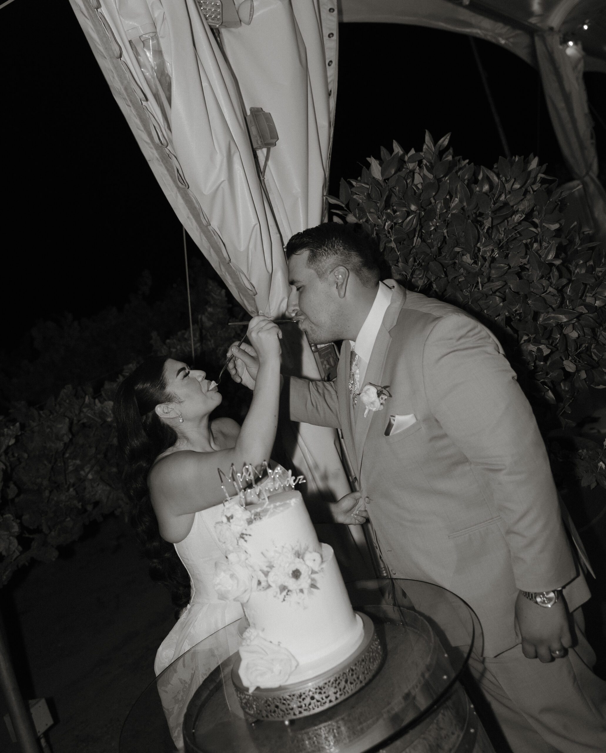Black and white photo of bride and groom's cake cutting