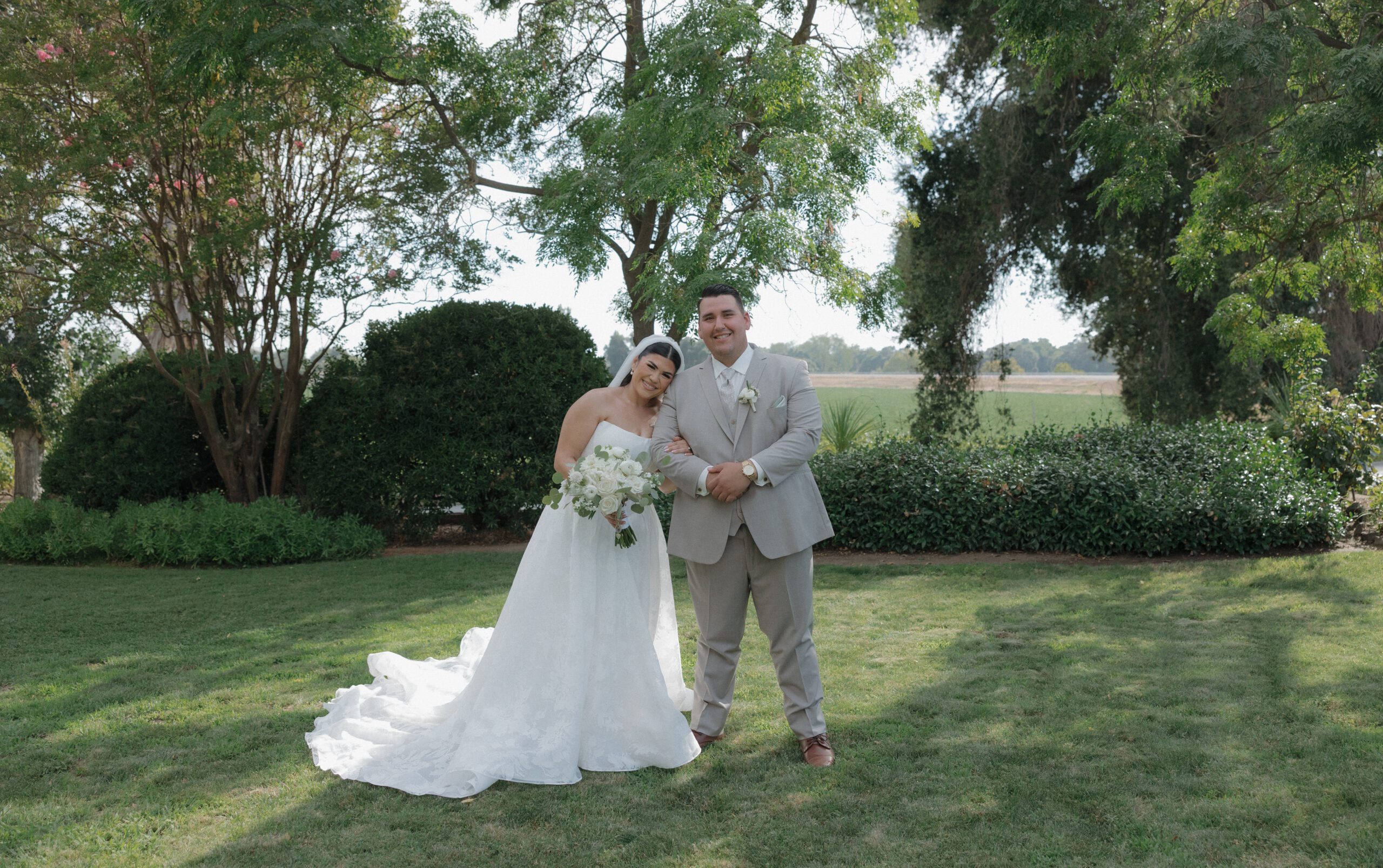 A photo of bride and groom smiling with bride leaning her head on groom's shoulder