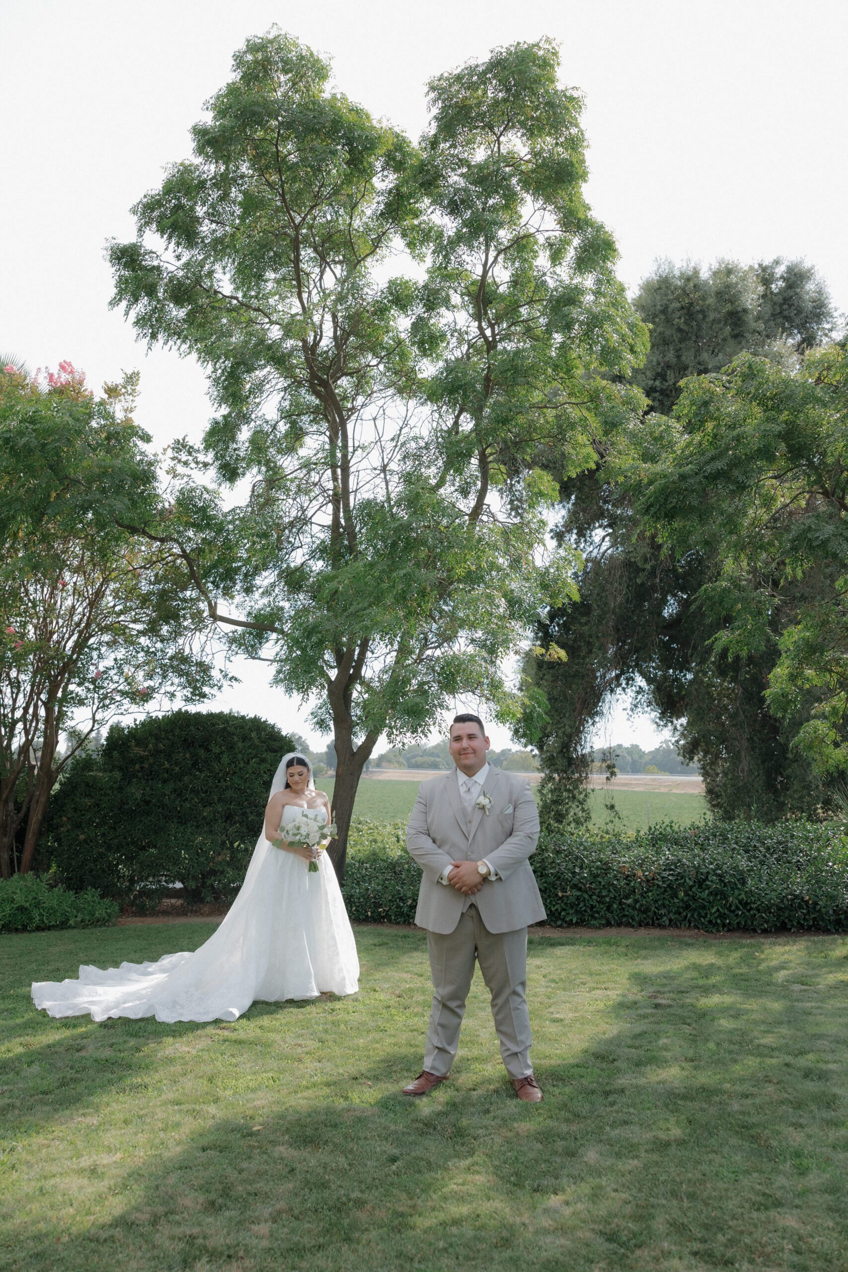 Editorial wedding photo of bride standing behind groom