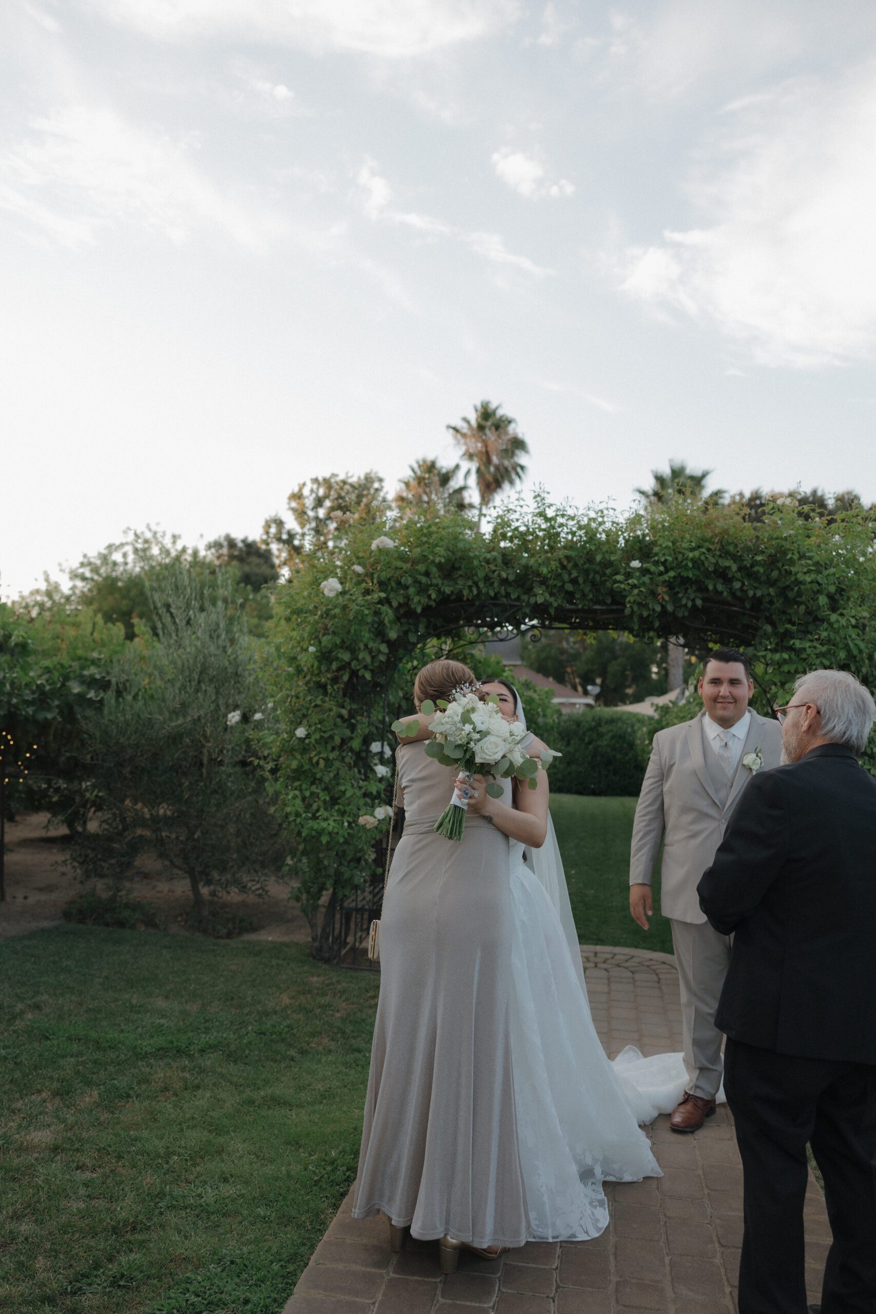 Candid wedding photo of bride hugging her mom