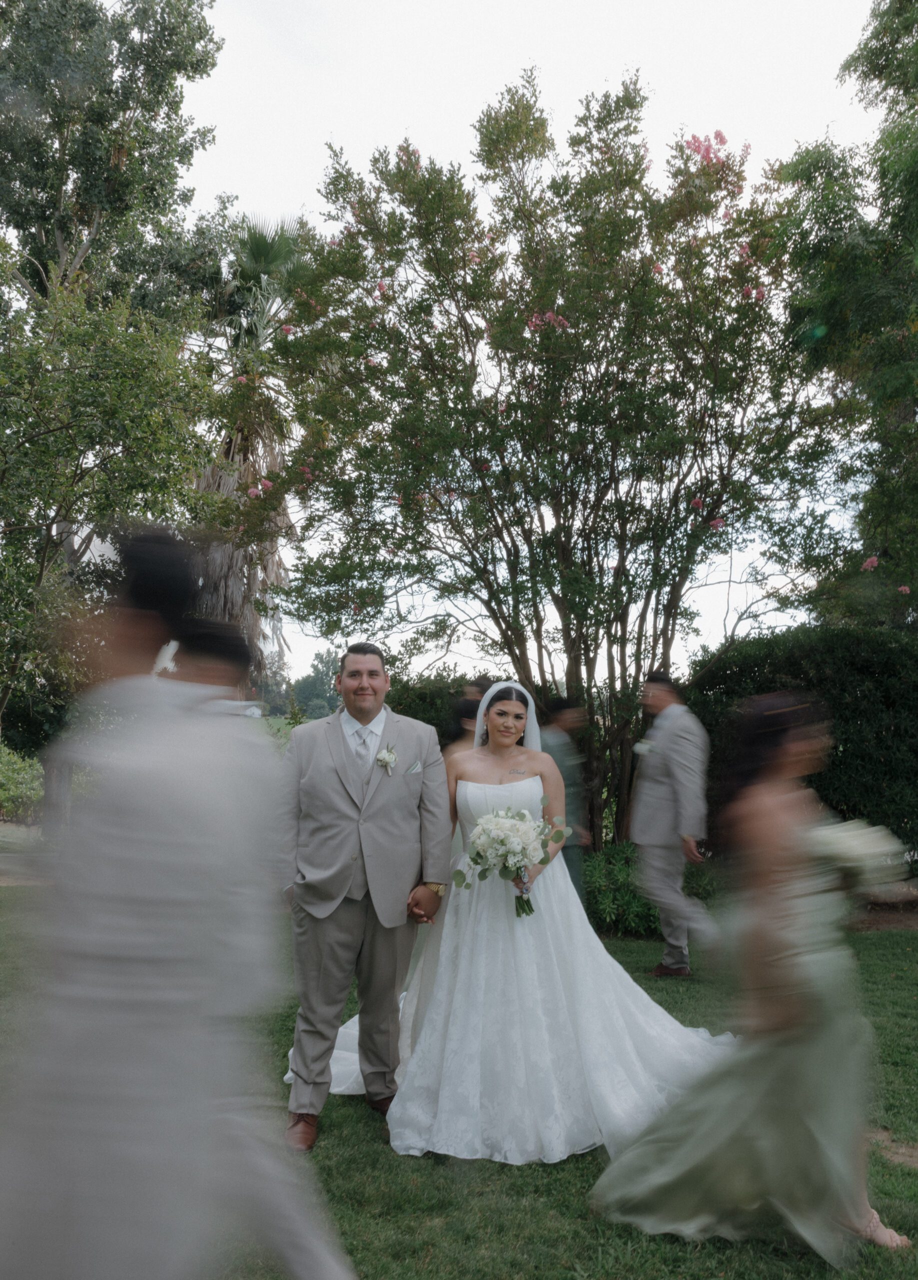Bridal party photo with wedding party walking past couple