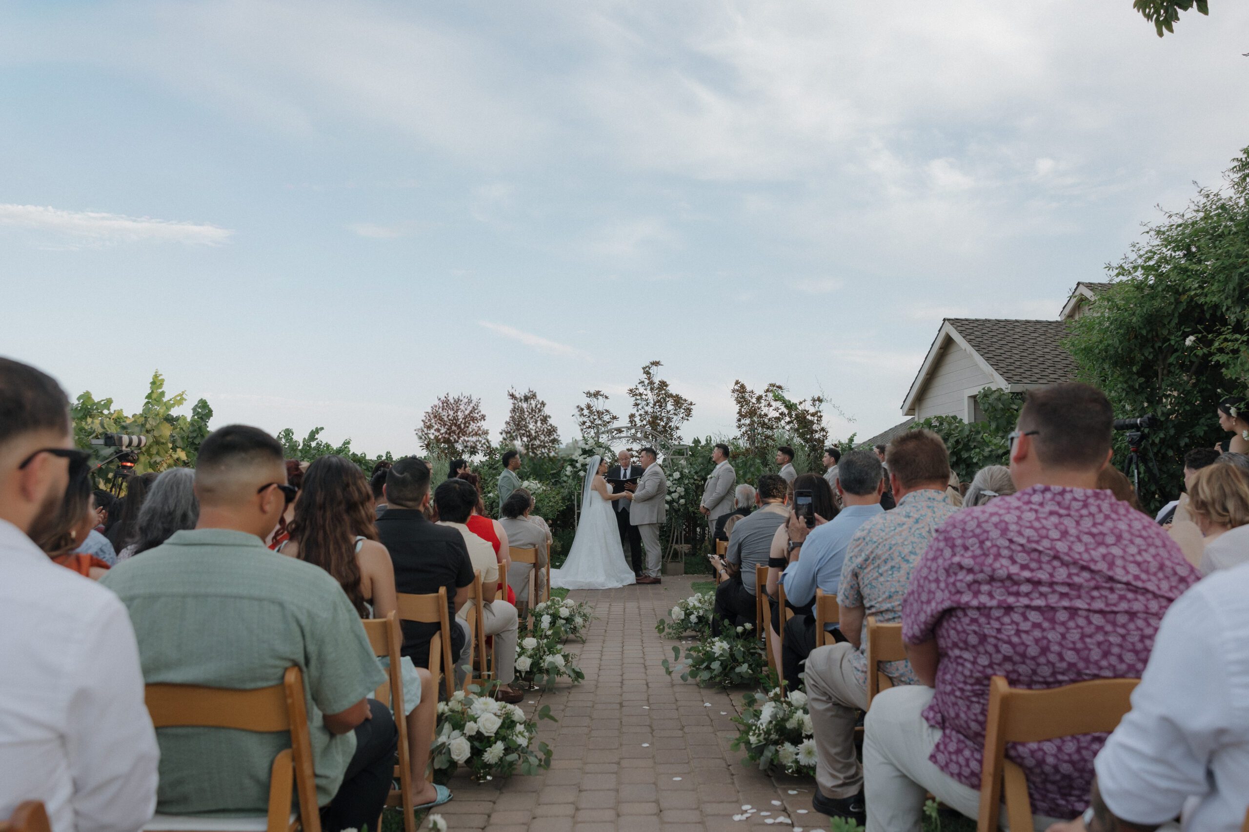 Wedding guests watching an outdoor wedding ceremony