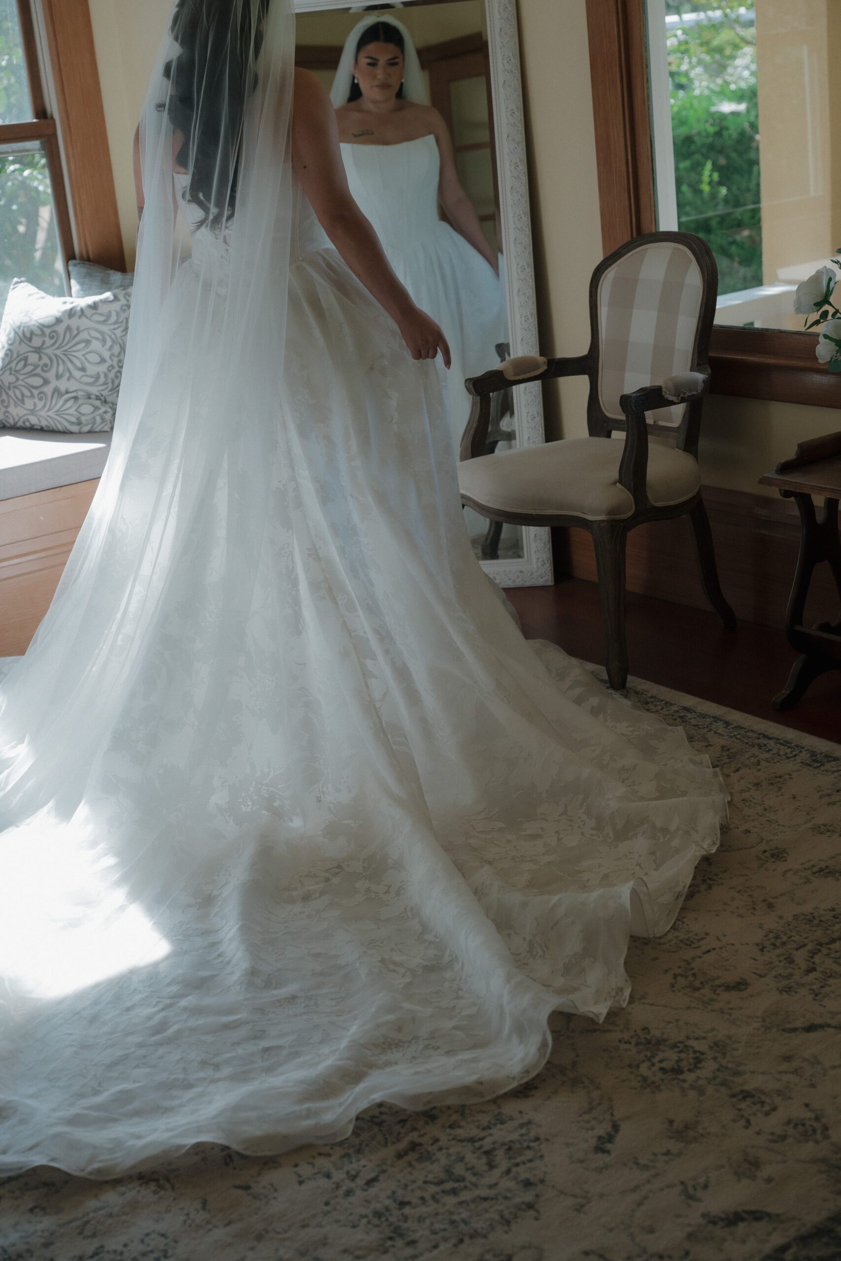 Bride getting ready in a space at Scribner Bend Vineyards looking in the mirror